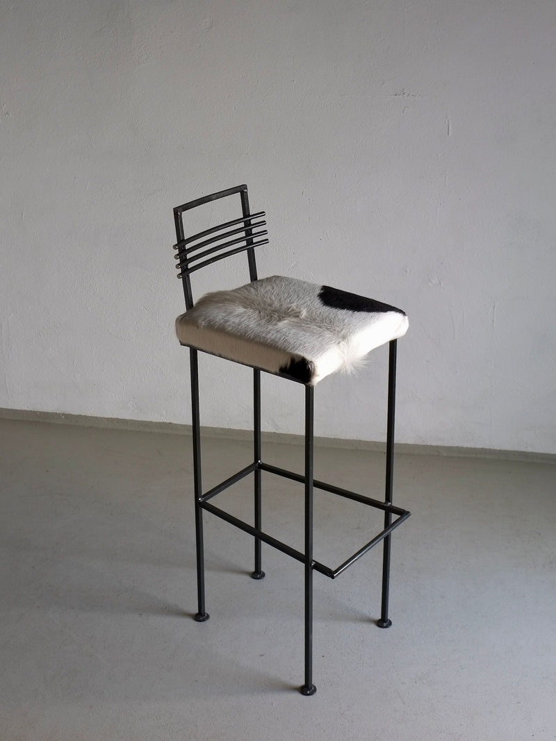 Modern wrought iron bar stool with cowhide seat and linear backrest