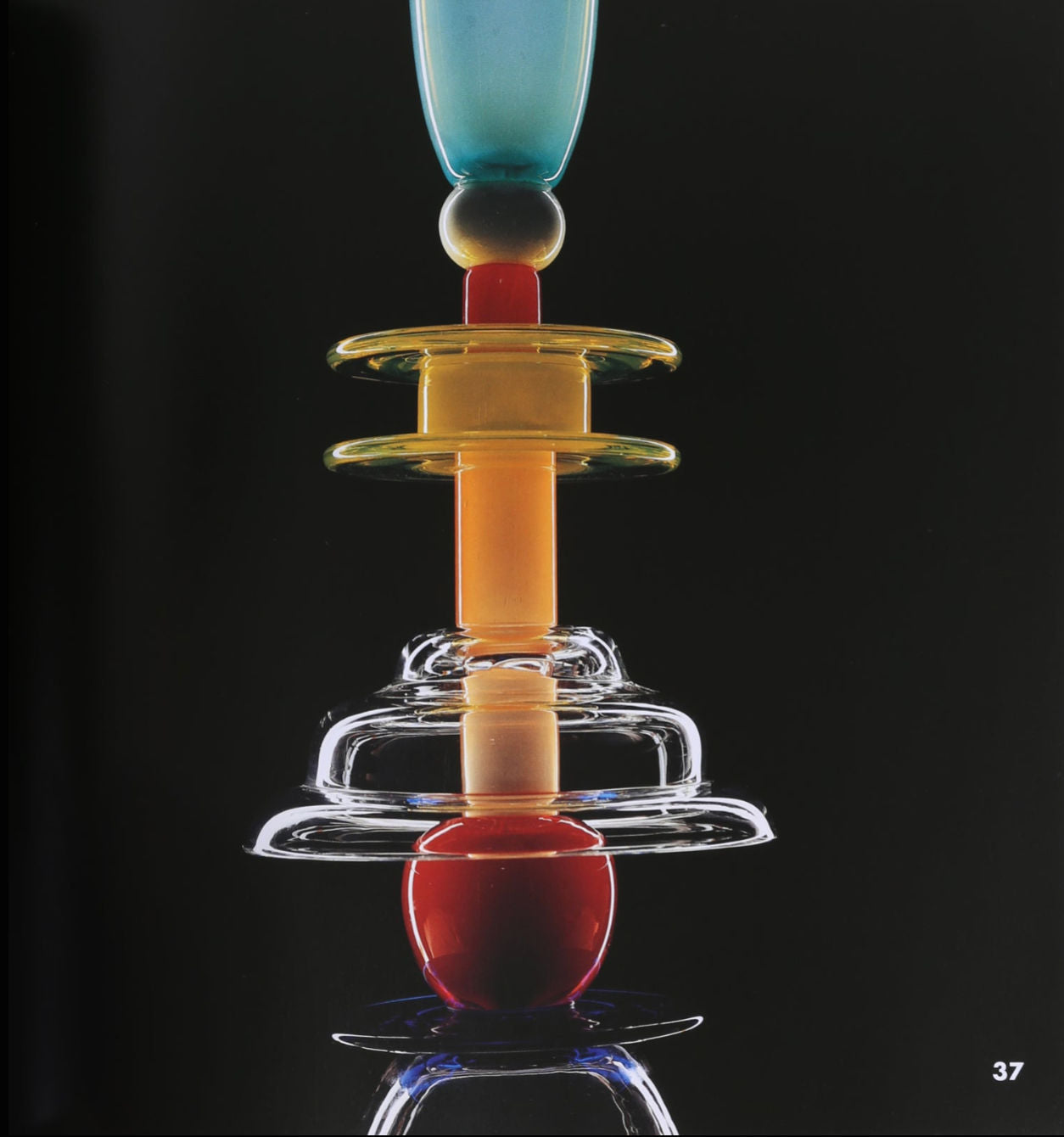 The "Ettore Sottsass, Glass Works Book" by Villa features a vibrant abstract glass sculpture with stacked geometric shapes in blue, yellow, orange, red, and clear glass on a black background; number 37 appears in the lower right corner.