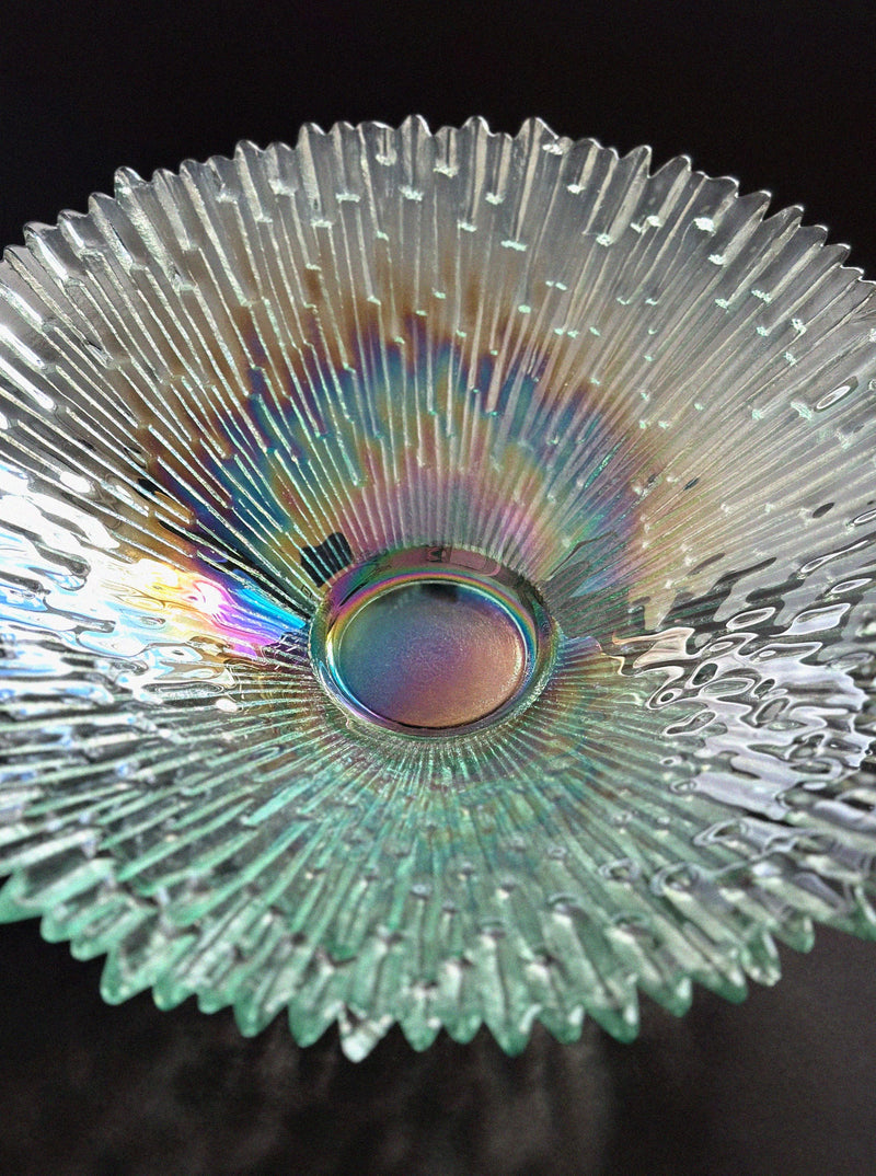 The Vintage Stories Tapio Wirkkala "Revoltunet" Art Glass Bowl features a rippled, textured surface with iridescent rainbow hues, reminiscent of iconic Humppila Finland designs, beautifully set against a dark background.