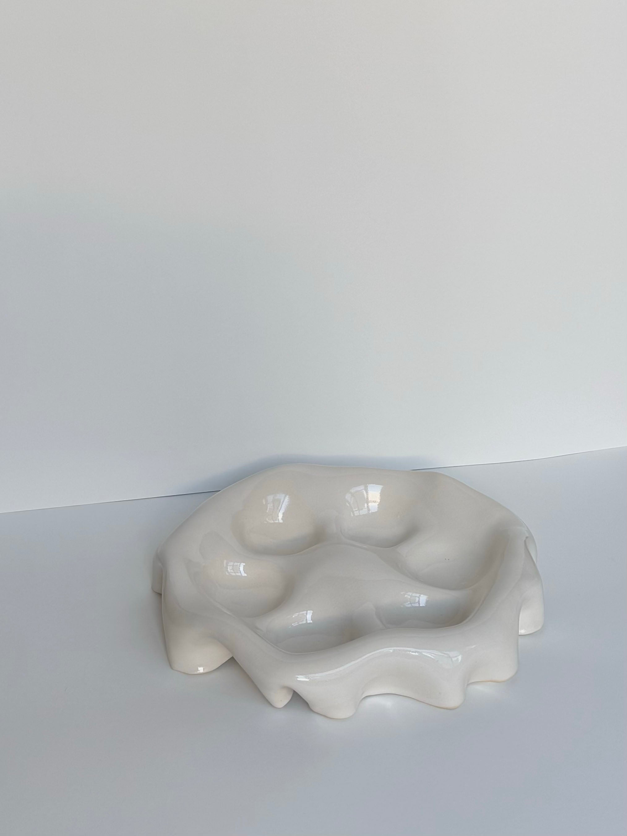 The Ceramic Snack Plate by Goobs Ceramics, made from hand-crafted stoneware clay, is a glossy, unevenly shaped white dish with wavy edges and multiple shallow compartments. It sits on a white surface against a light gray background.