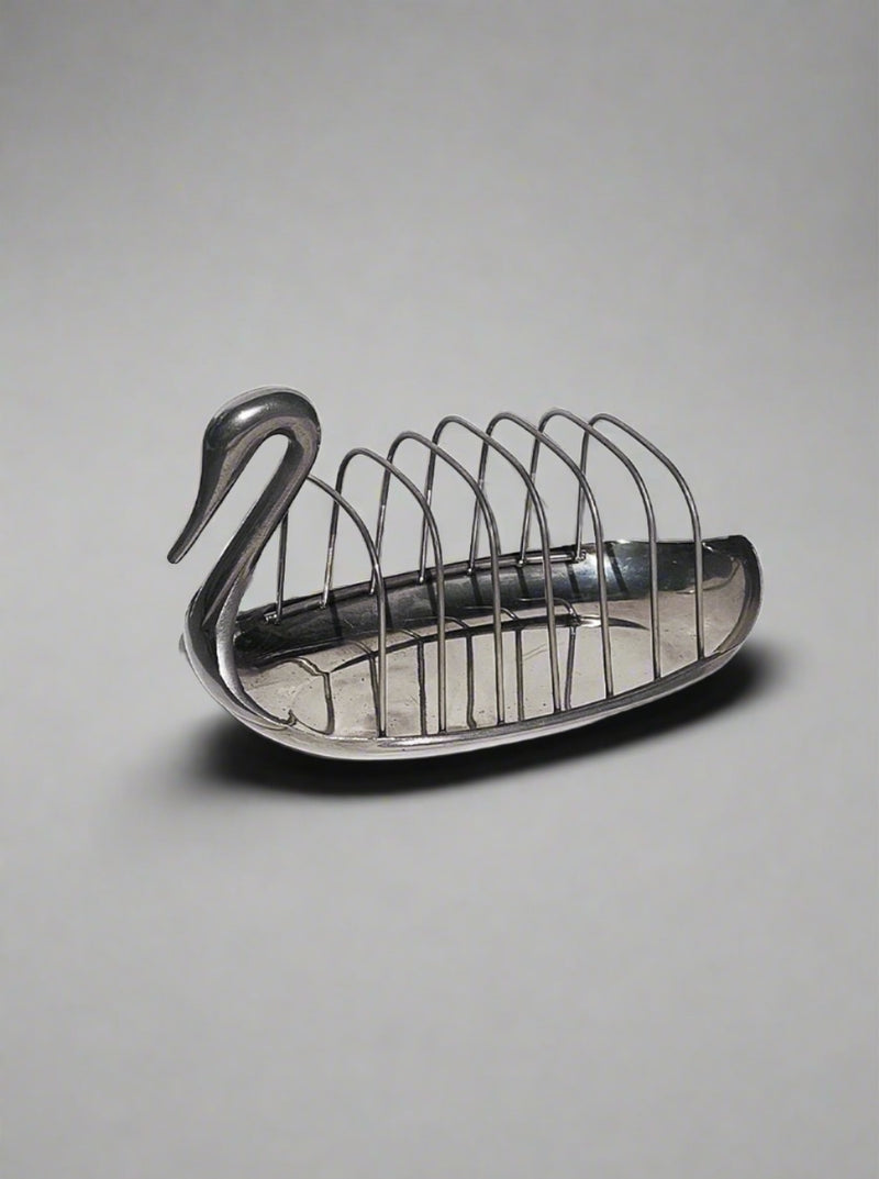 A decorative brass Les Objoies swan-shaped toast rack with six slots, designed to hold slices of bread, depicted against a white background.