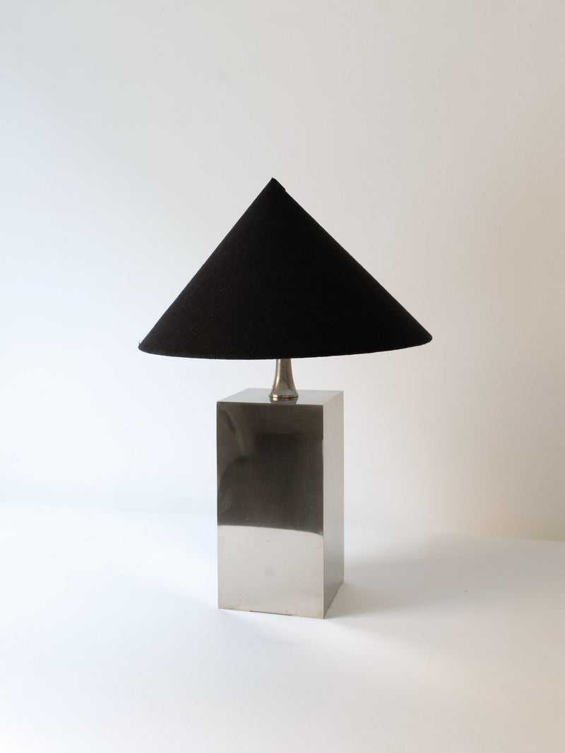 A Barbier Small Box Lamp 1970s by Collection apart, featuring a sleek chrome-over-brass rectangular base and a black conical shade, sits on a white surface against a plain background. The French 1970s lighting piece boasts a minimalist design and a smooth finish.