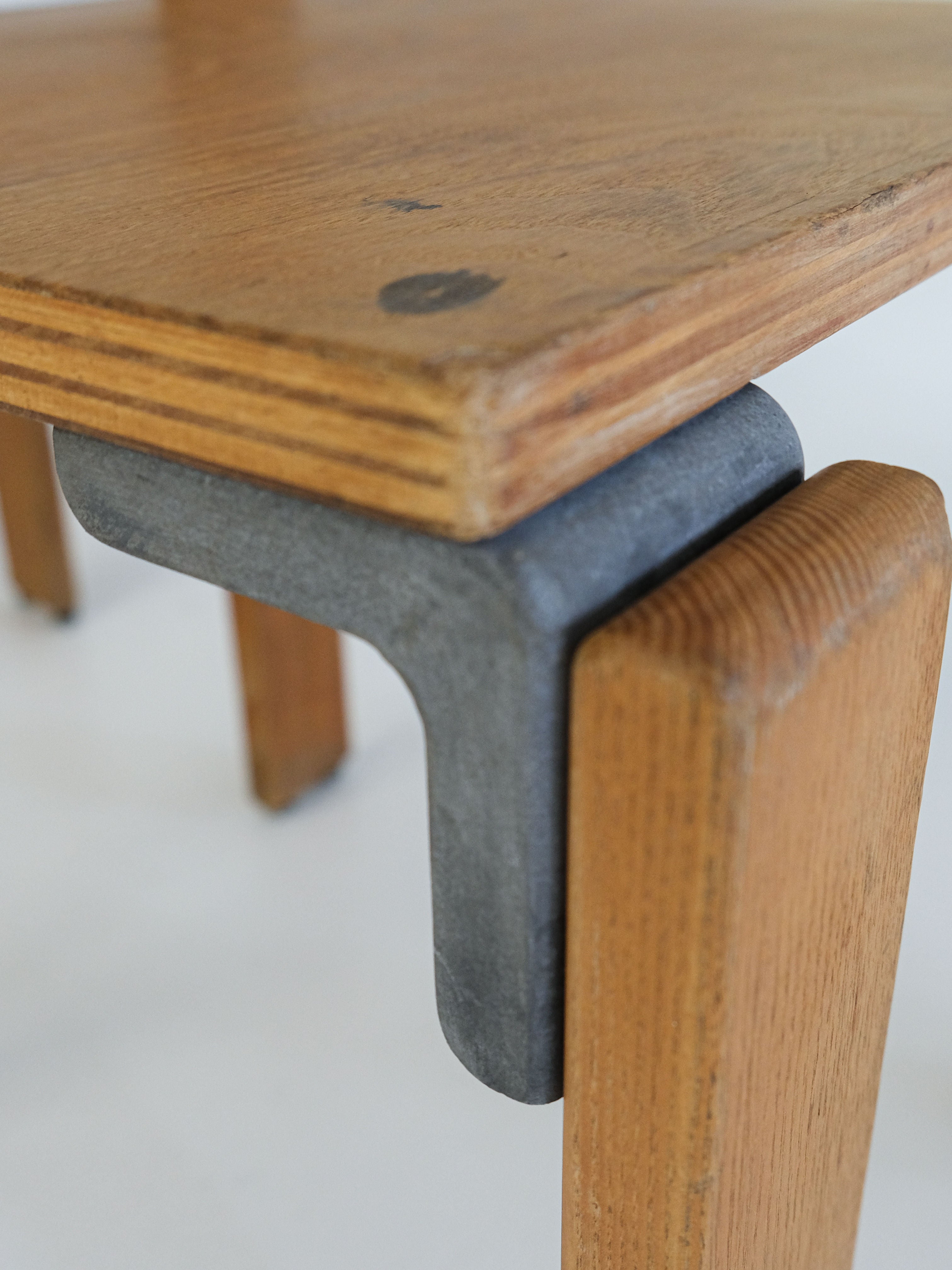 Close-up of a vintage "Les Carats" Dining Chair by George Candilis and Anja Blomstedt, 1970s, from antibeige. Showcasing minimalist design with detailed craftsmanship in the natural wood grain and metal connectors attaching the leg to the tabletop.