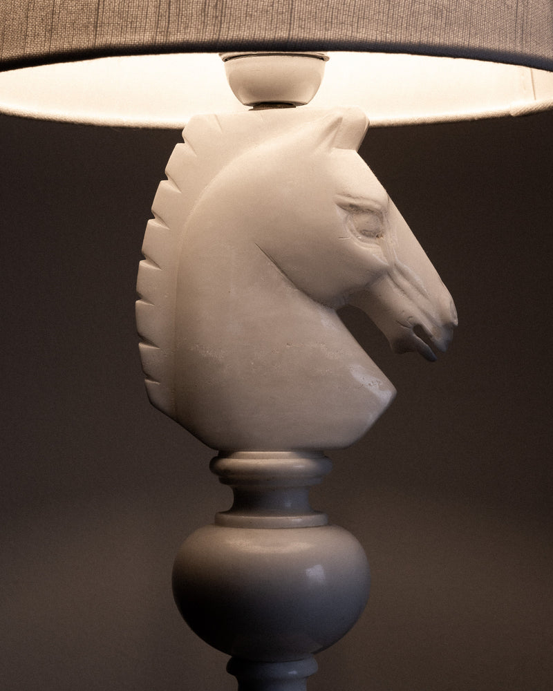 The Spigel Italian Alabaster Chess Knight Table Lamp (1970s) features a white knight-shaped base and fabric shade, evoking hand-carved Italian craftsmanship against a neutral backdrop.