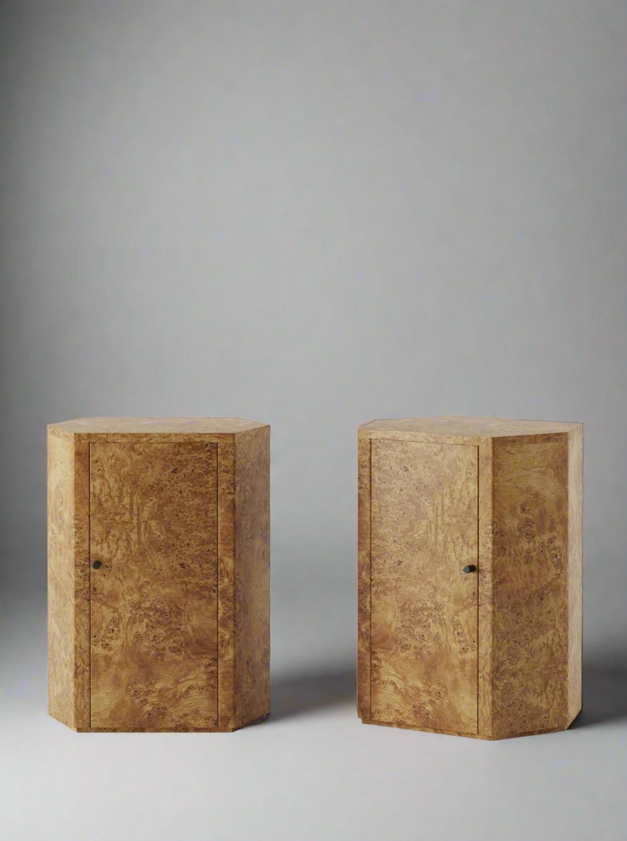 The Pair of Park Night Stands in Poplar Burl by Lemon features two rustic, hexagonal wooden cabinets with a smooth, polished finish set against a white background. Each nightstand is designed with a single front door that includes a small dark knob, showcasing the natural wood grain and texture; they exemplify meticulous craftsmanship in every detail.