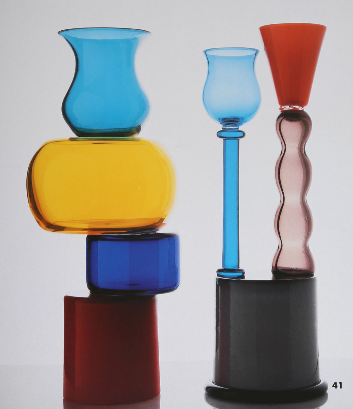 Villa's "Ettore Sottsass, Glass Works Book" features vibrant glass art in blue, yellow, red, and black—each uniquely shaped with smooth and wavy forms—arranged on a white backdrop with the number 41 below.