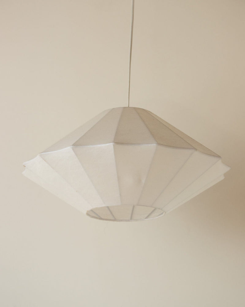 White pleated cocoon pendant light suspended from ceiling