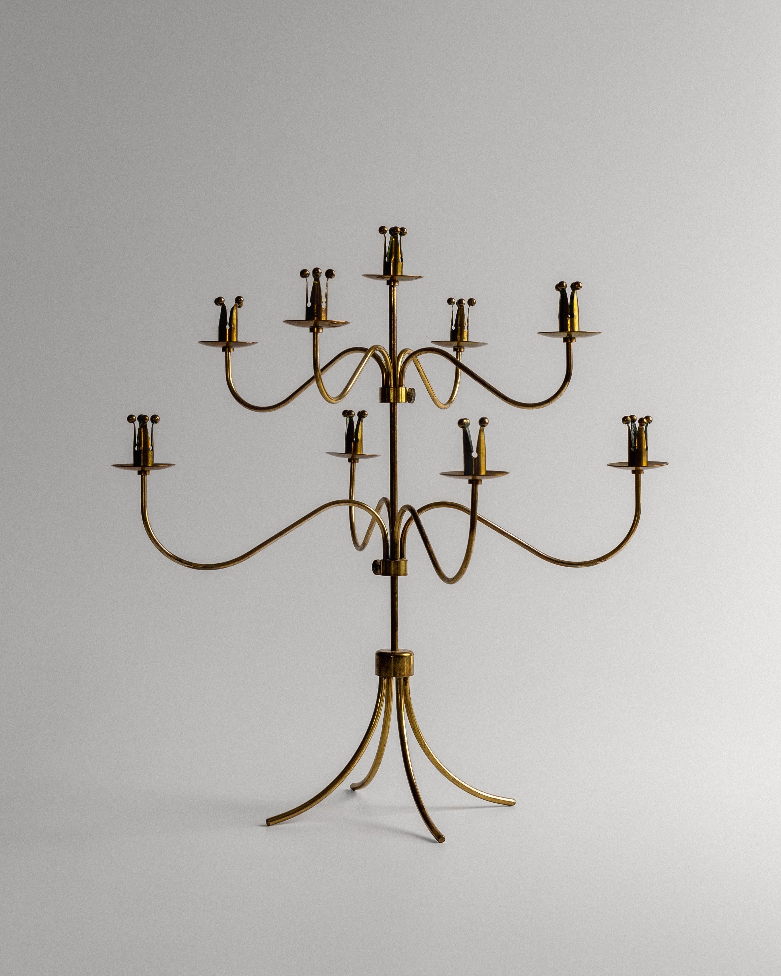 A large, ornate Spigel Brass Candelabra from Sweden, dated to the 1950s, boasts a gold finish and features 16 candle holders arranged in an elegant, symmetrical design reminiscent of Scandinavian aesthetics. This Ystad Metall candelabrum stands on a base with four curved legs that provide sturdy support against a plain white background.