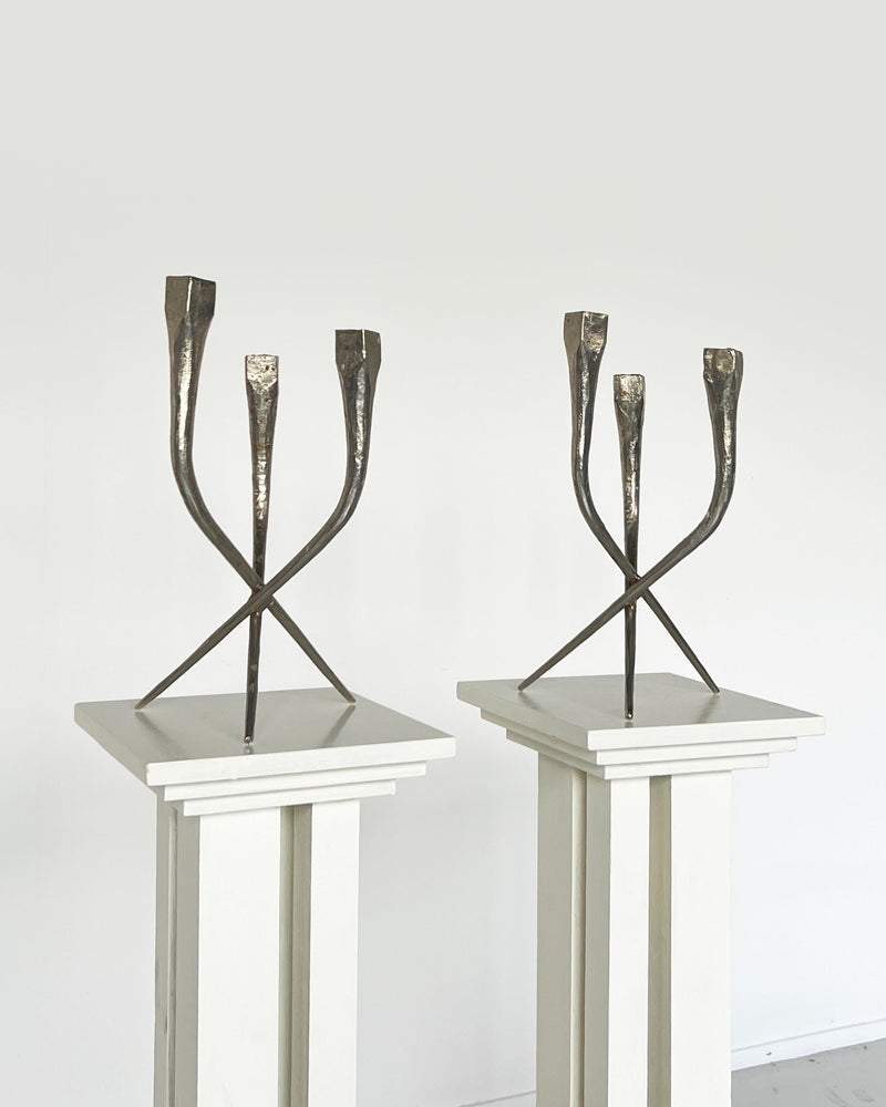 Pair of brutalist bronze candleholders with crossed legs design