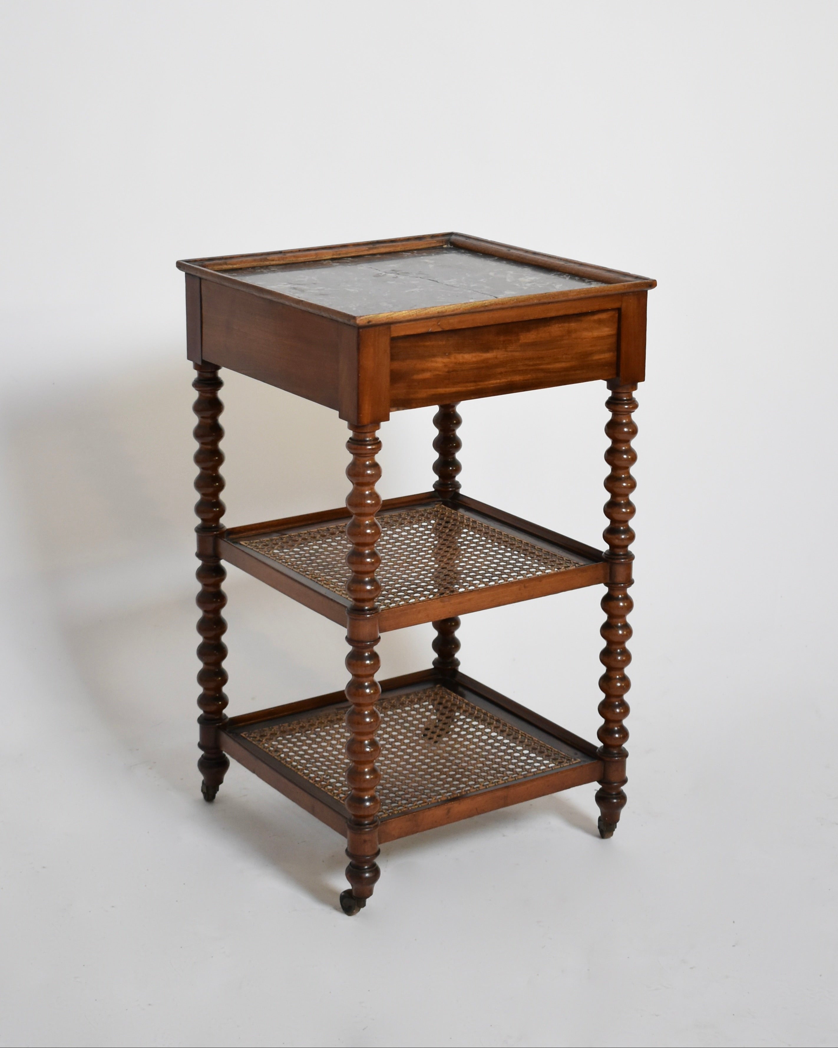 The Serving Table Two Trays, XIXth c. by Barracuda Interiors features a wooden frame, marble top, turned legs, two woven cane trays, and small wheels—blending classic antique charm with vintage style.