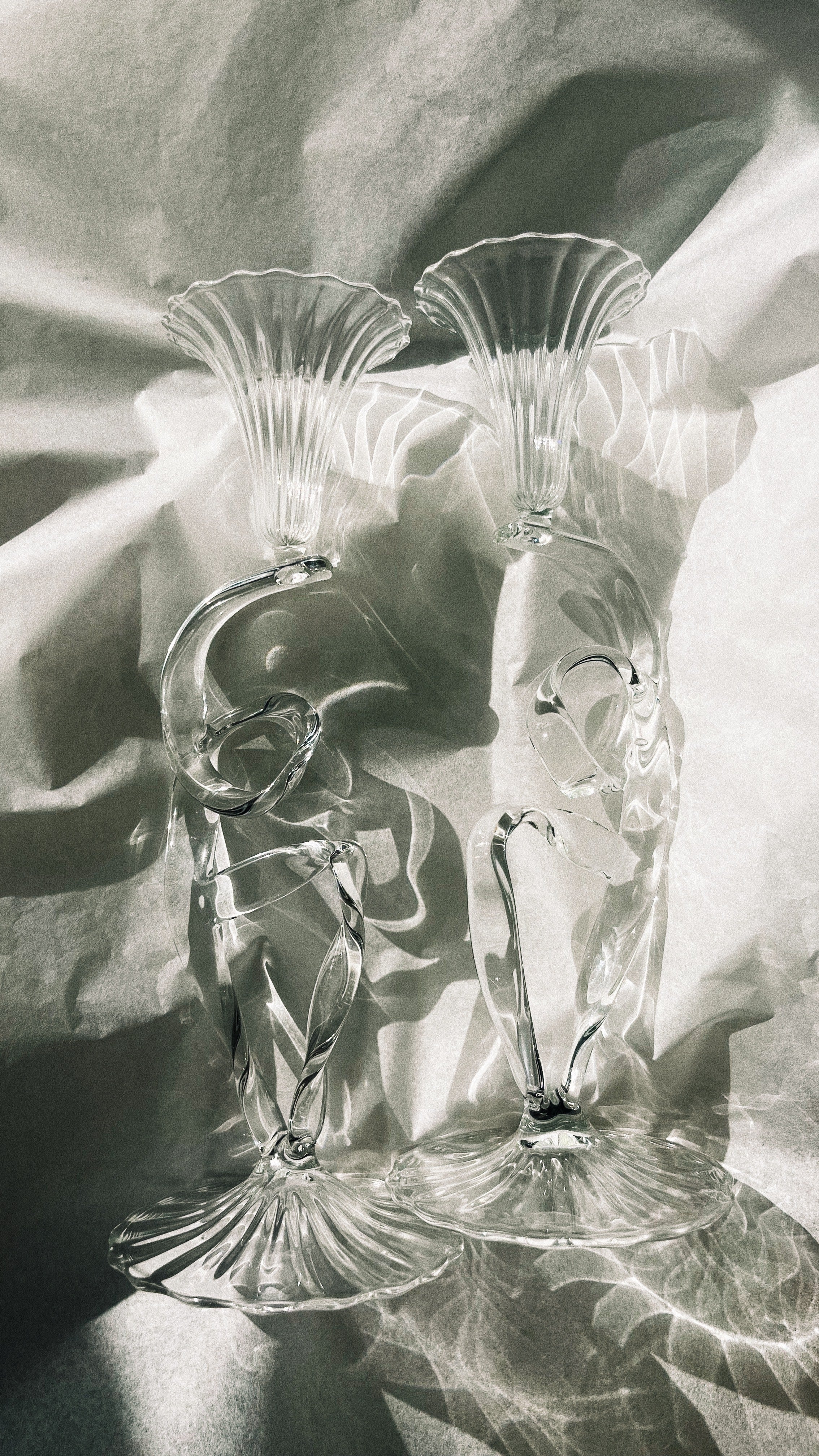 Crystal ribbon candleholder pair with fluted tops in dramatic lighting