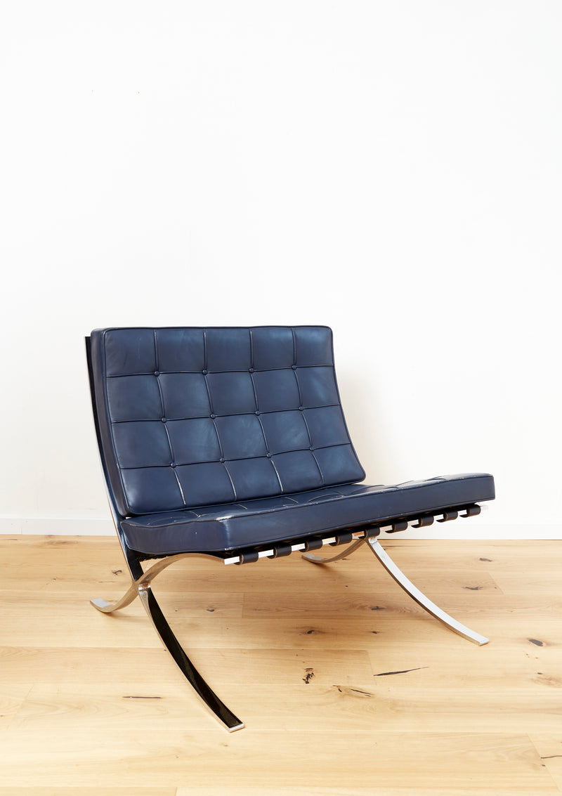 Blue leather Barcelona chair with tufted cushions and chrome frame