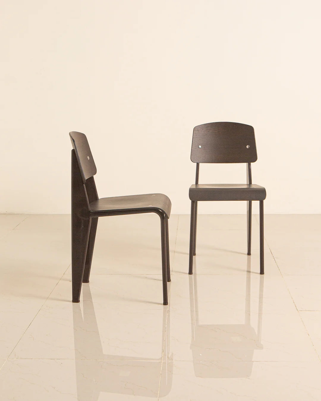 Two Jean Prouvé Standard chairs in dark wood, side and front view