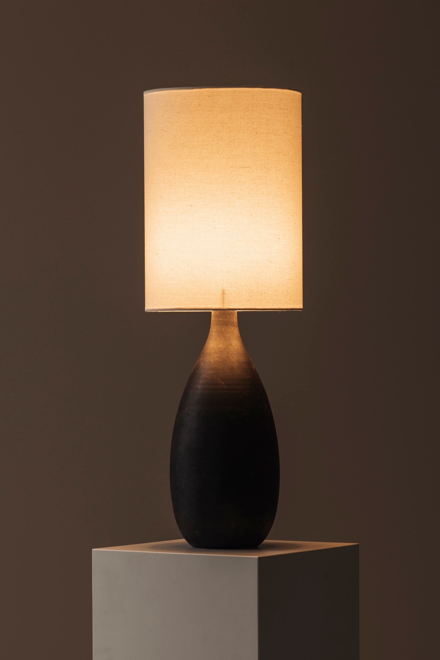 Sculptural Ceramic Table Lamp from Sweden, 1960s — lit lamp on white pedestal