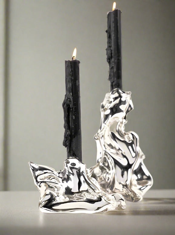 Silver melted candle holders with black candles by Agustina Ros