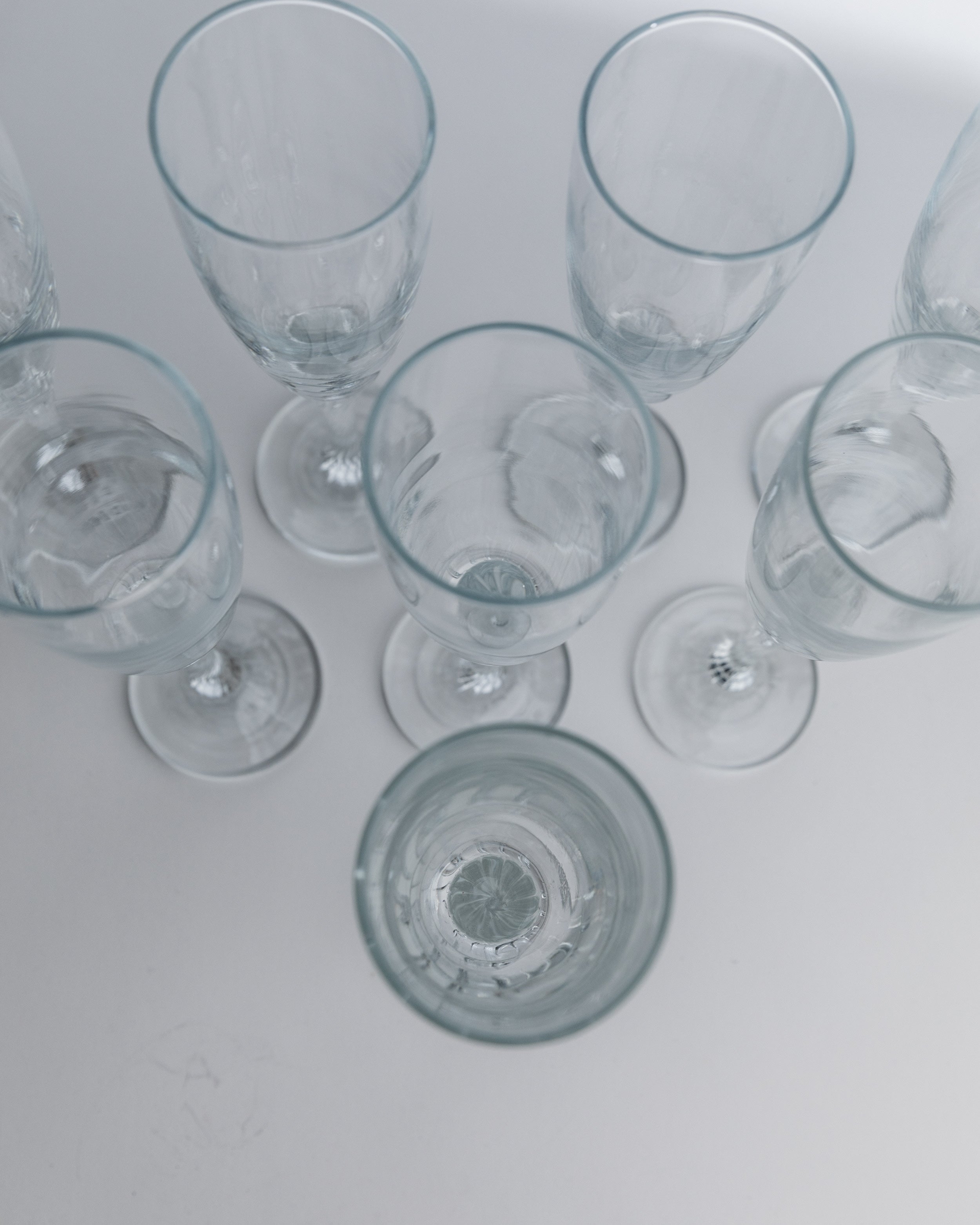 Set of 1980s champagne glasses viewed from above on white surface