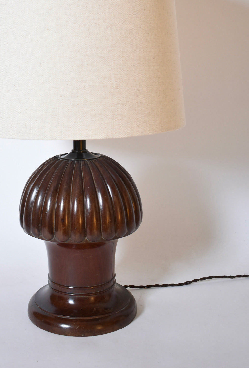 The Barracuda Interiors Pine Shape Wooden Lamp, 1930s, features a ribbed dark wood base and beige fabric lampshade with twisted cord, showcased on a plain white background.