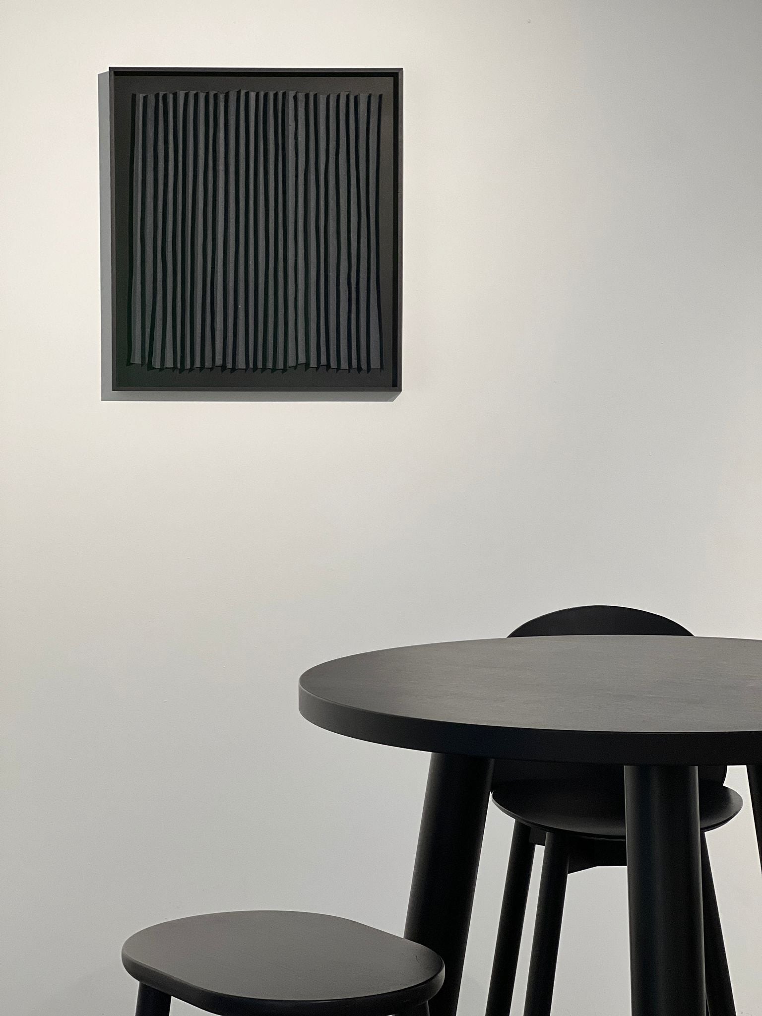 Rhythm Black' Paper Composition — mounted on wall above black dining table