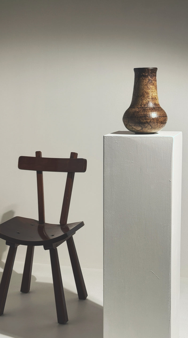 Stoneware vase by Jacques Pouchain displayed with vintage chair