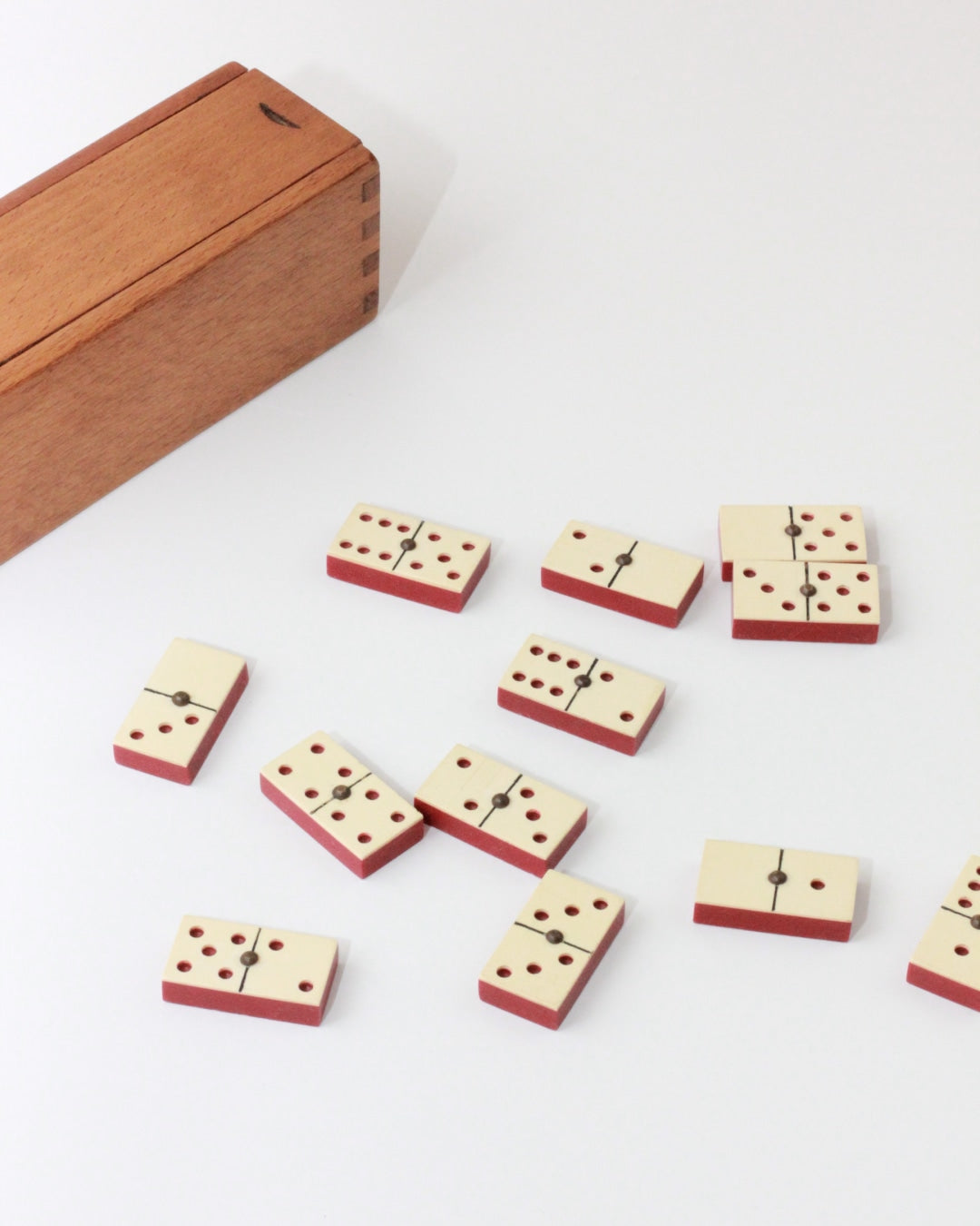 Mini Domino Set — top view of ivory and red dominoes on white surface