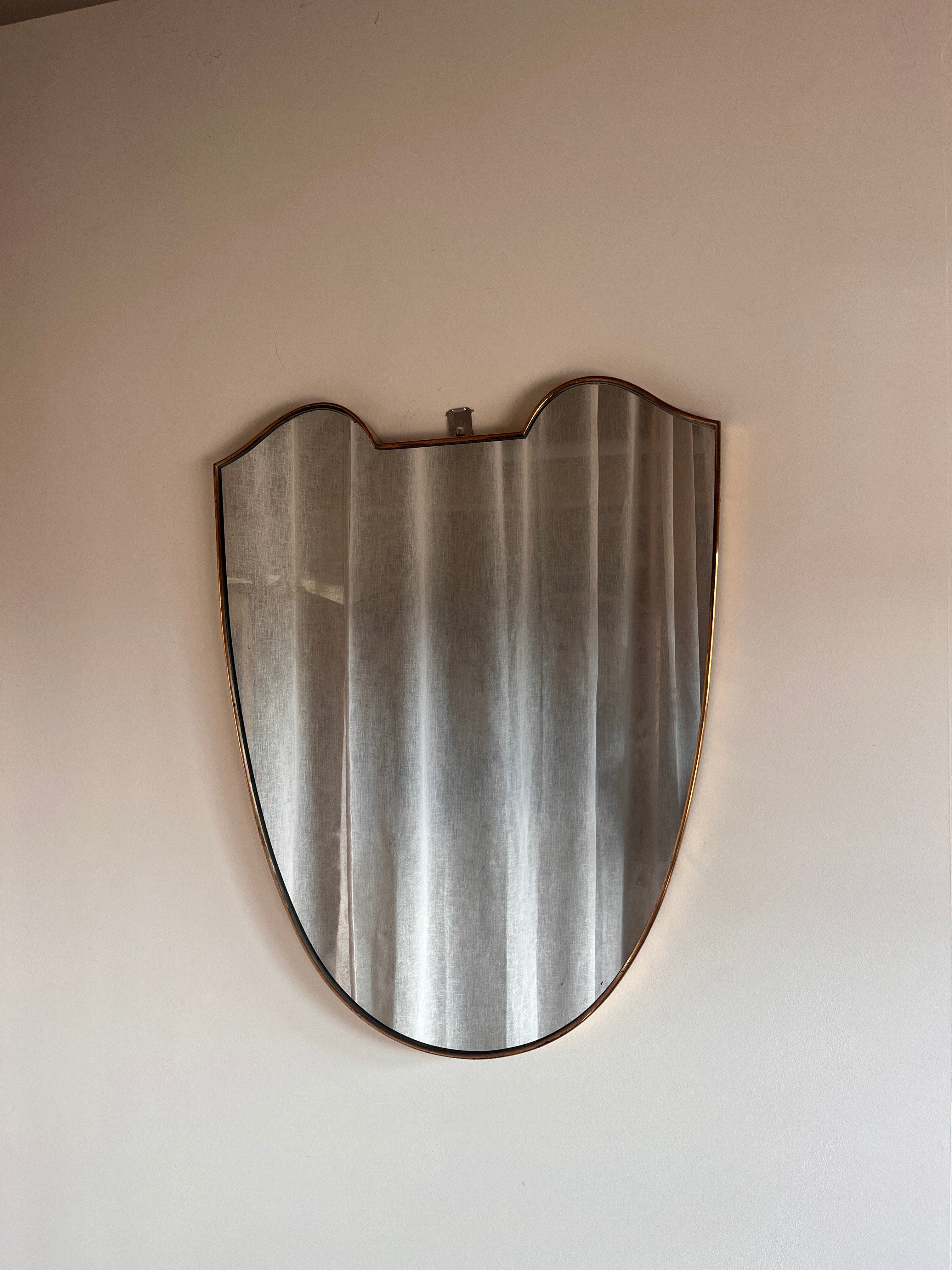Large Midcentury Italian Brass Shield Mirror — front view against a wall
