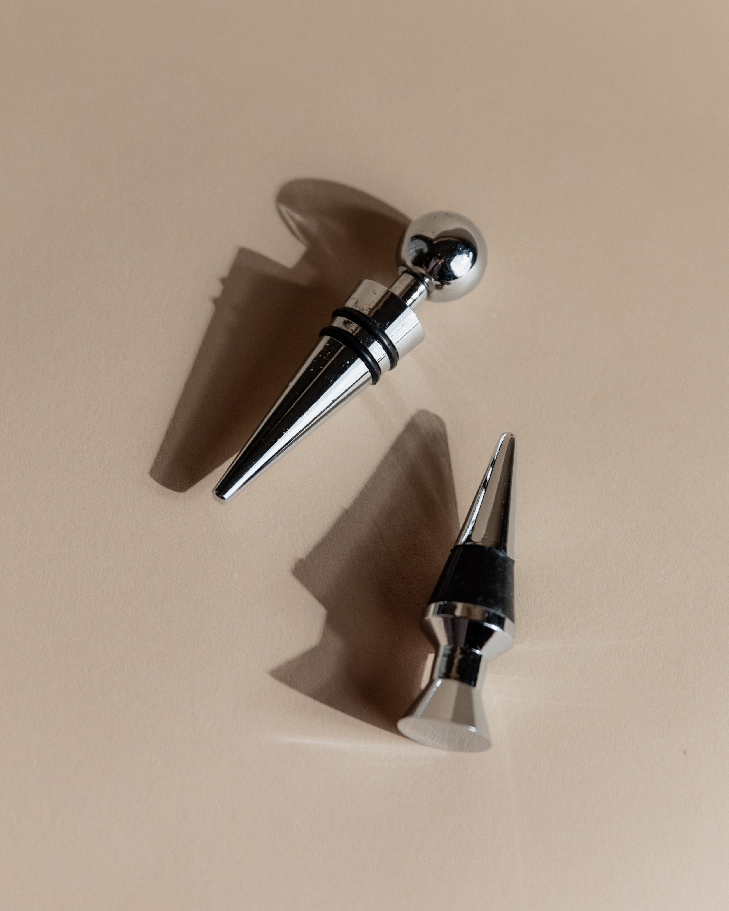 Vintage 1980s Bottle Stoppers Set of 2, Metal Geometric Conical Design Italy — angled view on neutral background