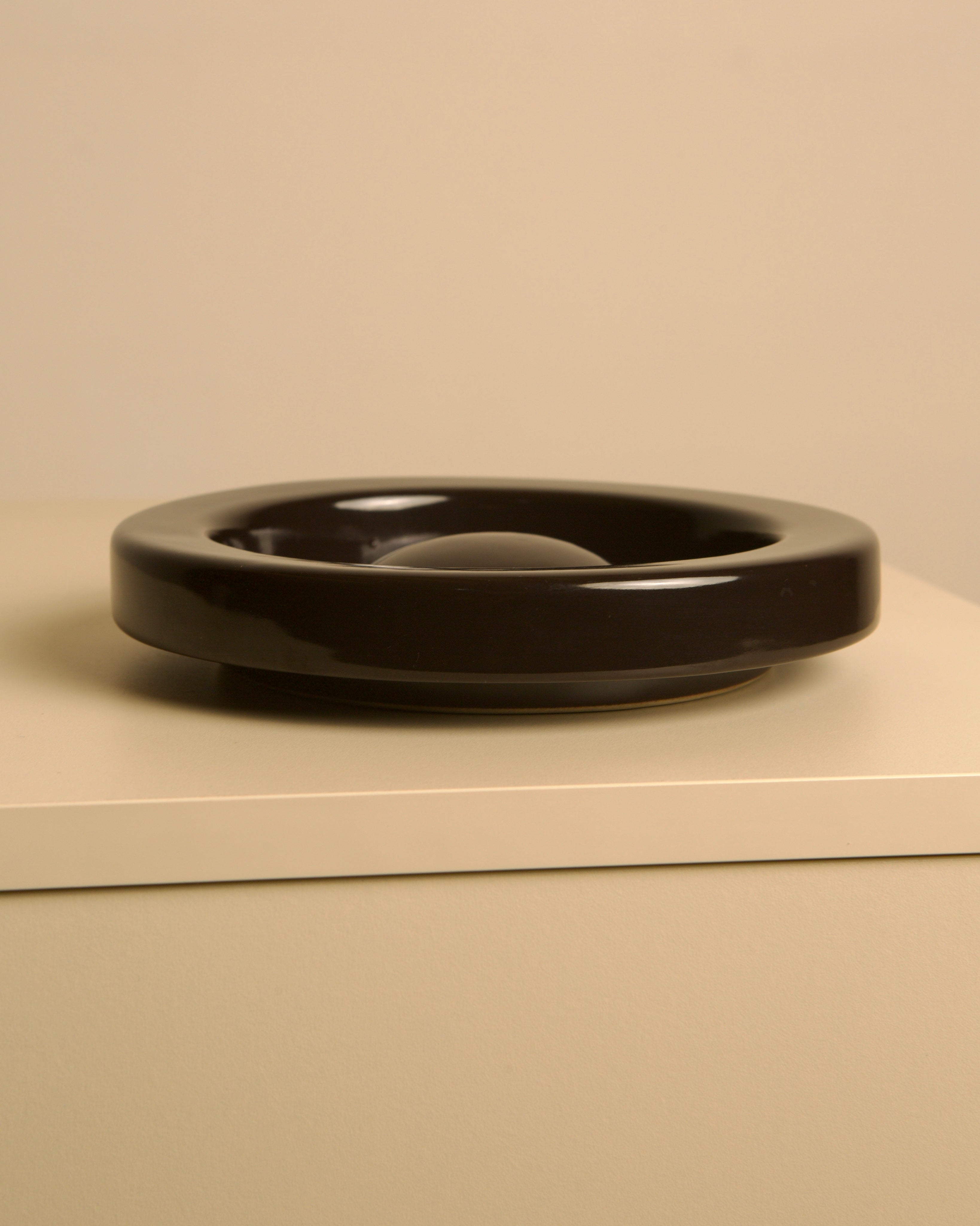Black ceramic ashtray by Sicart showing sleek circular design