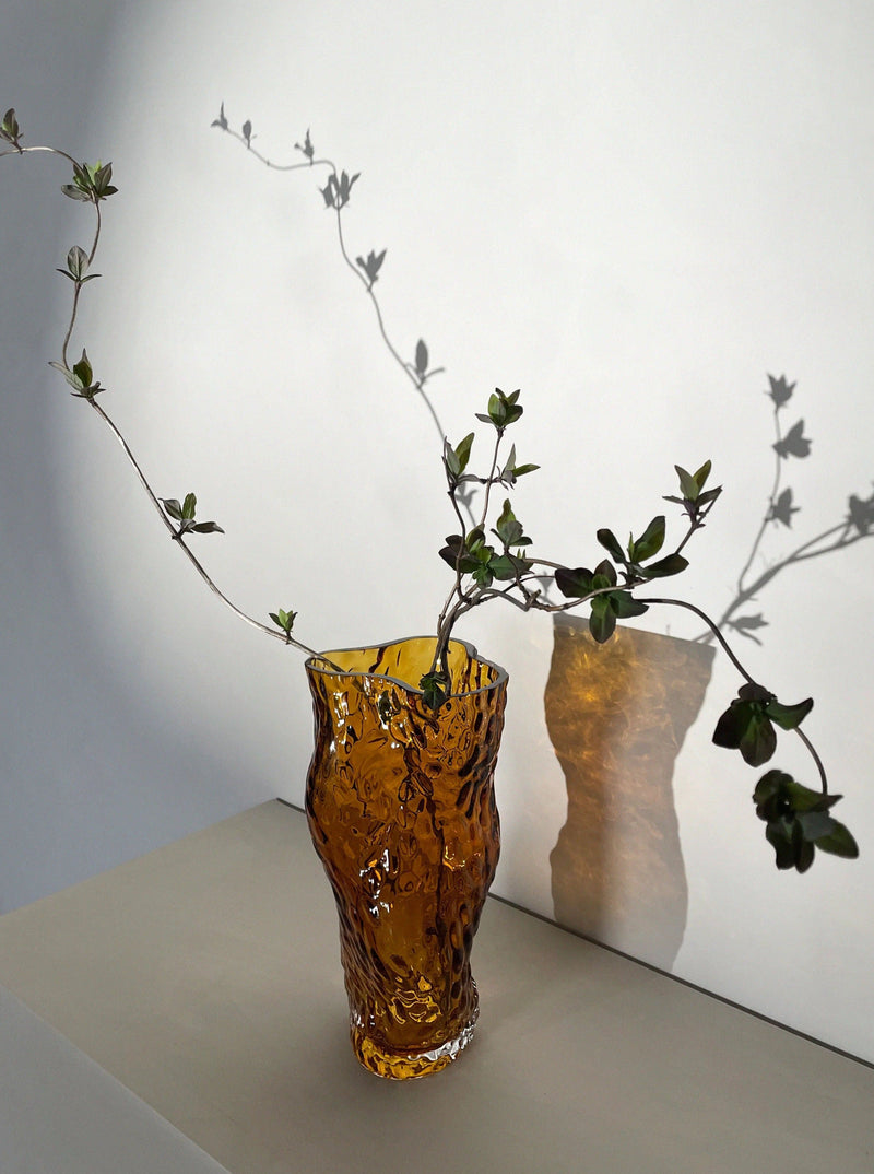 Ostrea Rock Glass Vase - Amber — close-up with branches against wall shadow