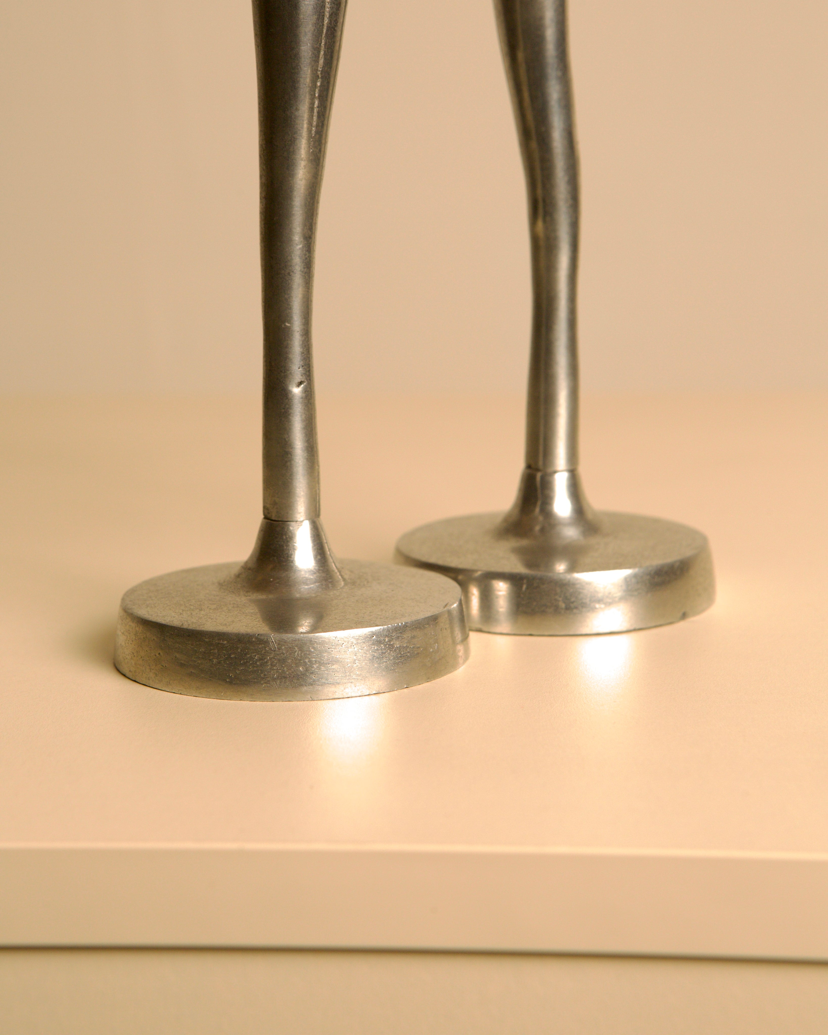 Pair of Italian aluminum dancers from the 80s — close-up of polished aluminum bases