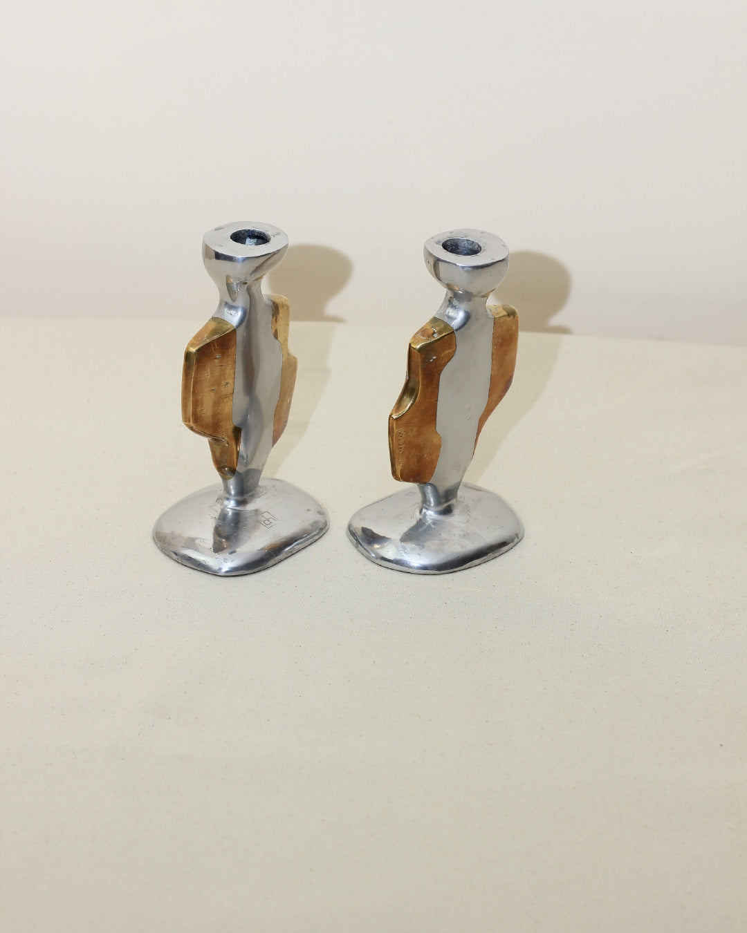 Brutalist Candleholders — angled view on neutral fabric background