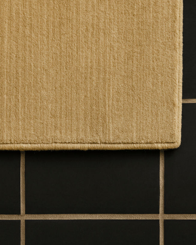 Rug 100% Wool New Zealand - Miel — corner view on black tiled floor