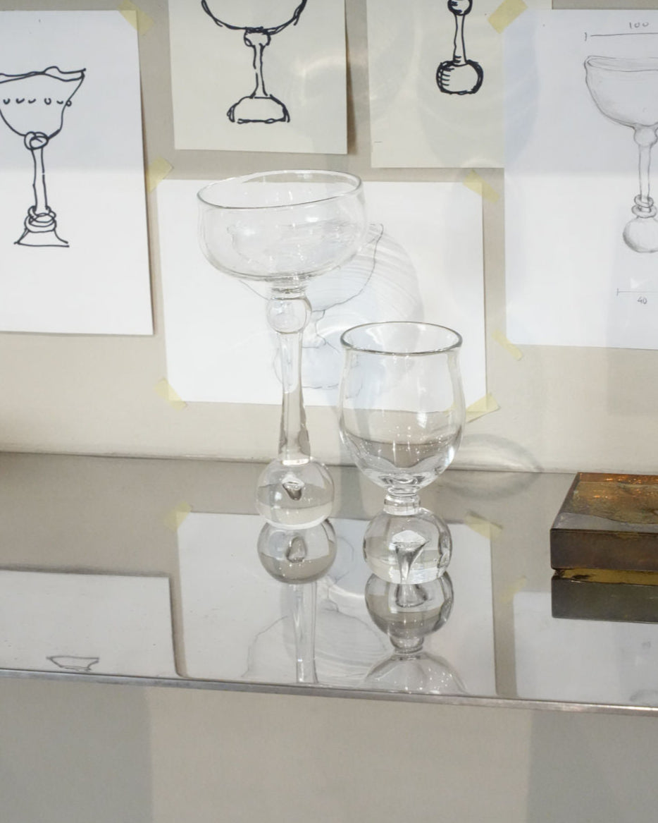 Eden glass stemware set with decorative spherical stems against design sketches