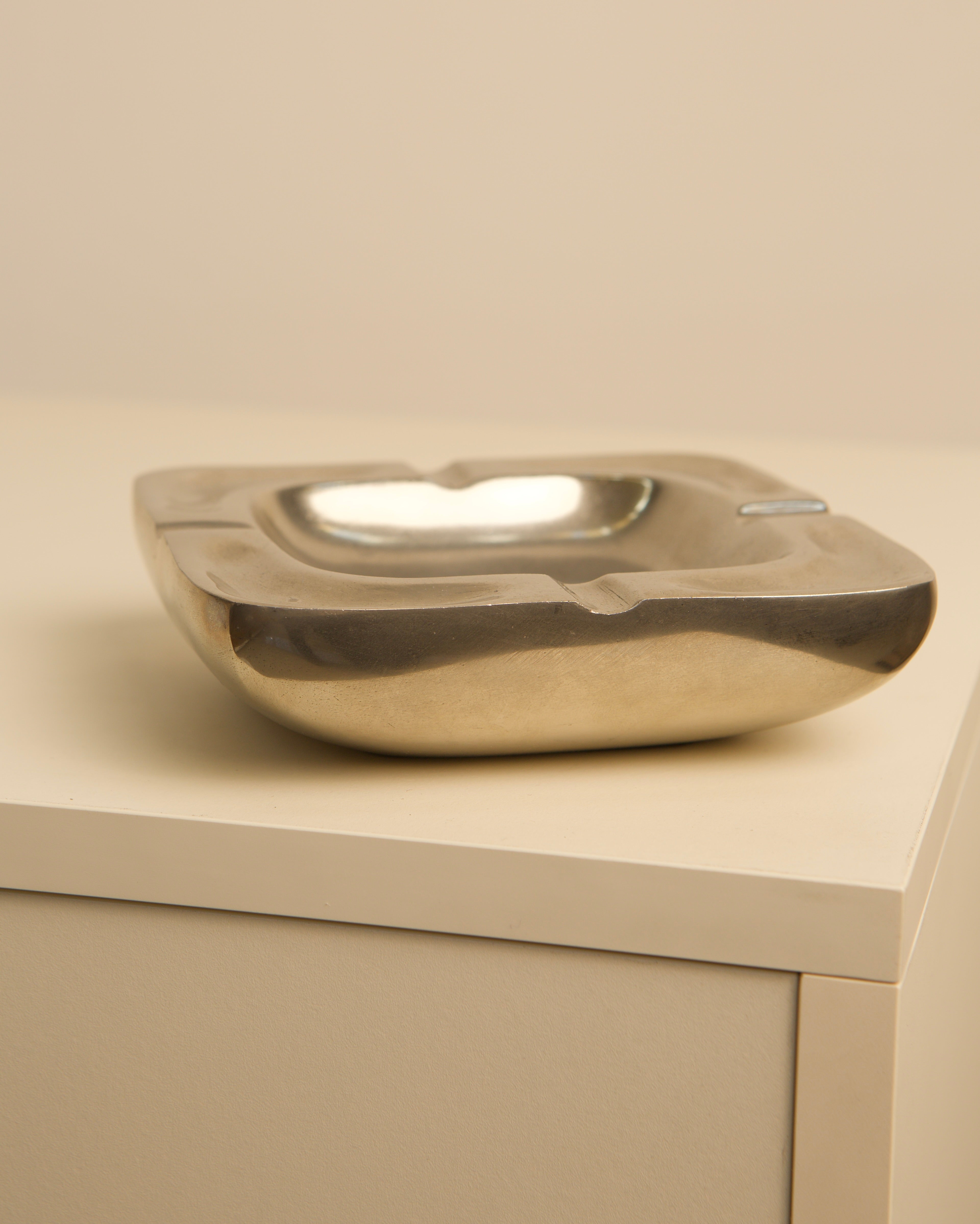 Golden aluminum square ashtray showing curved side profile detail