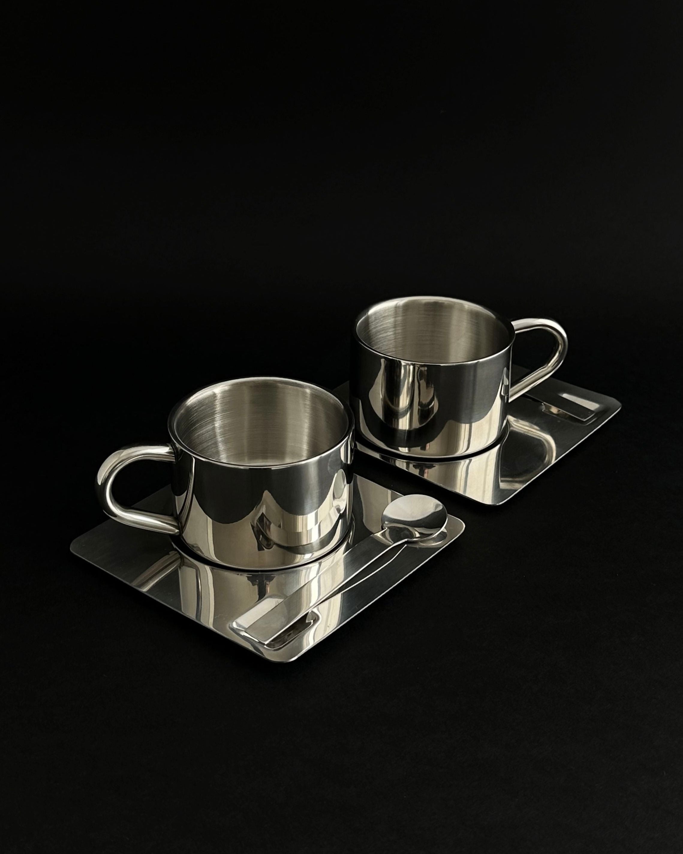 'HEDONISM' stainless steel cup with saucer — side angle