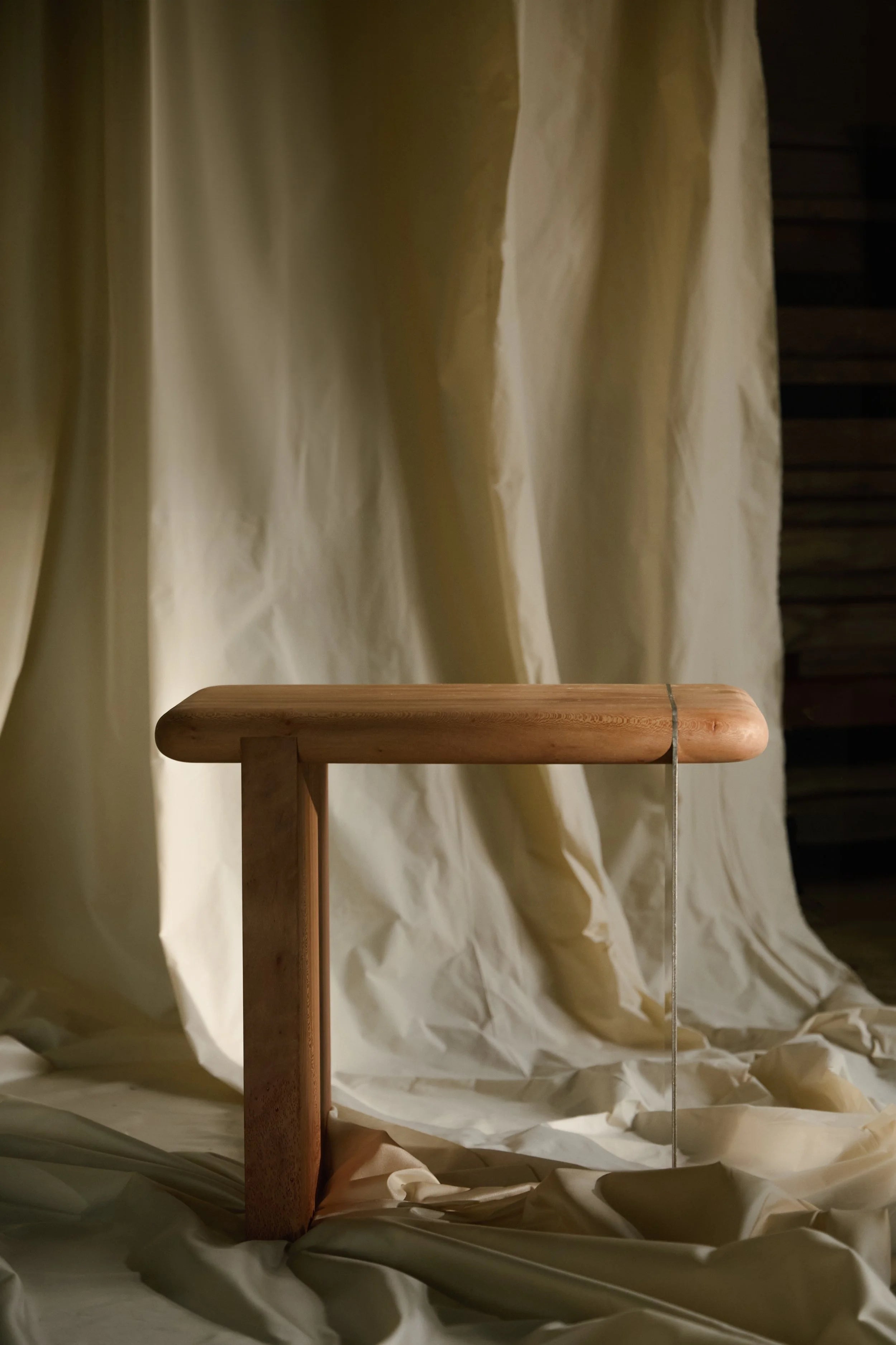 The Ferro Side Table — close-up of wooden frame against fabric backdrop