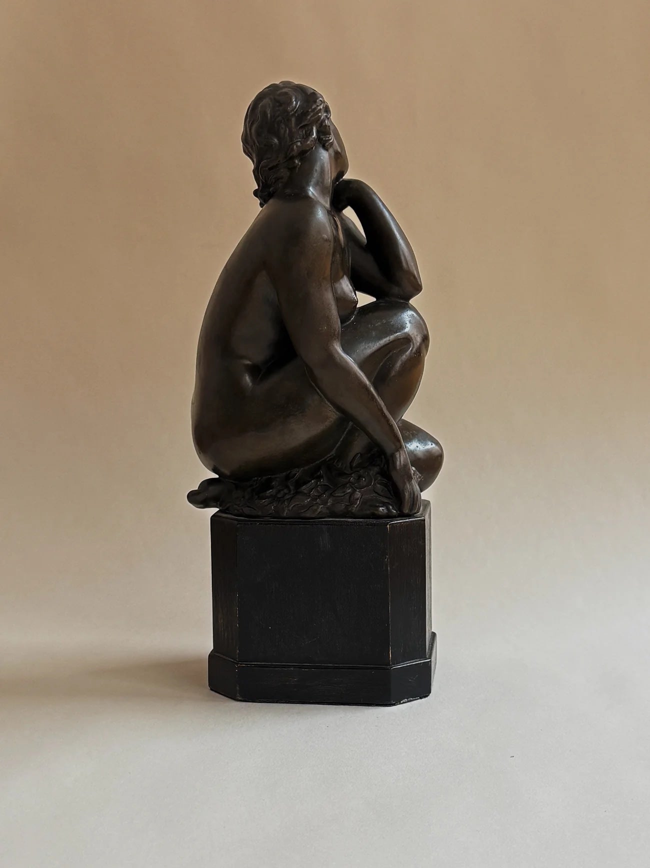 Bronze Sculpture of a Seated Woman — side angle showing detailed figure on black base