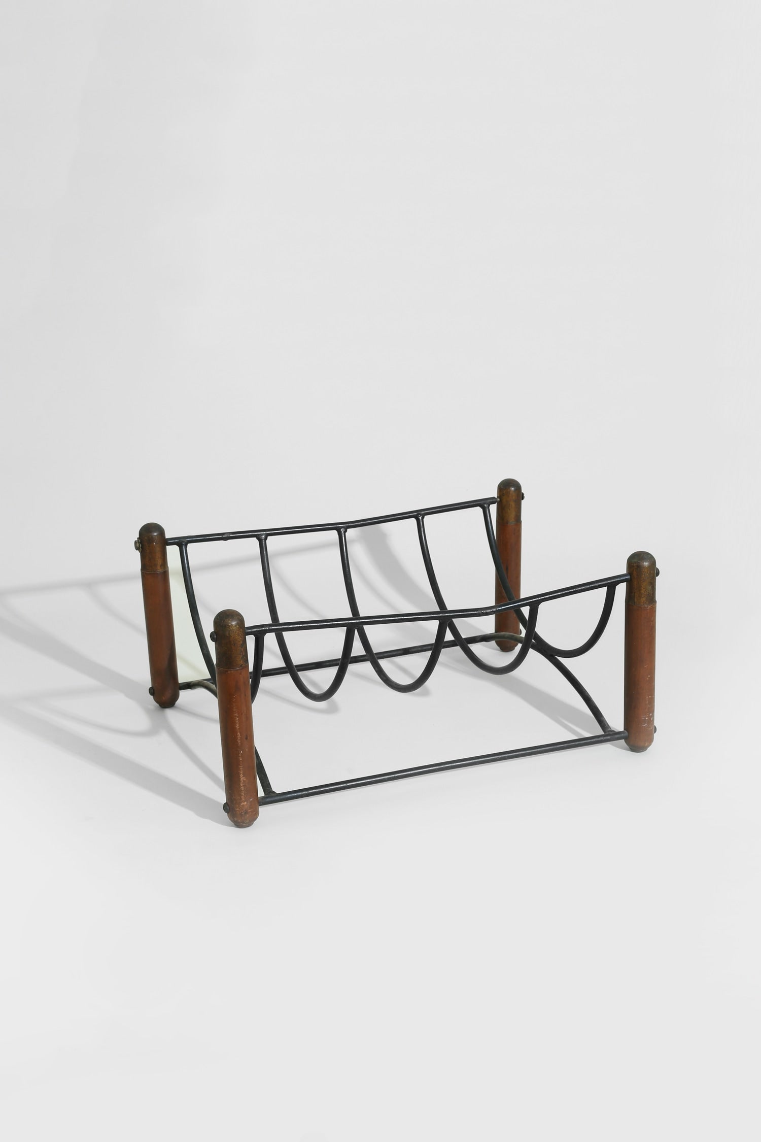 Mid-century Magazine Rack — close-up of black metal frame and wooden legs