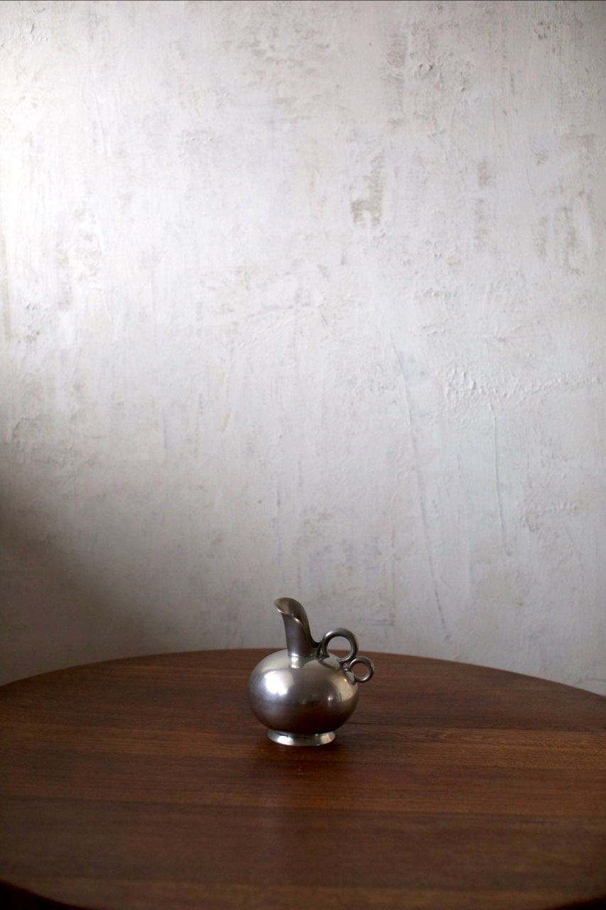 Tin Vase — side angle on wooden table against textured wall