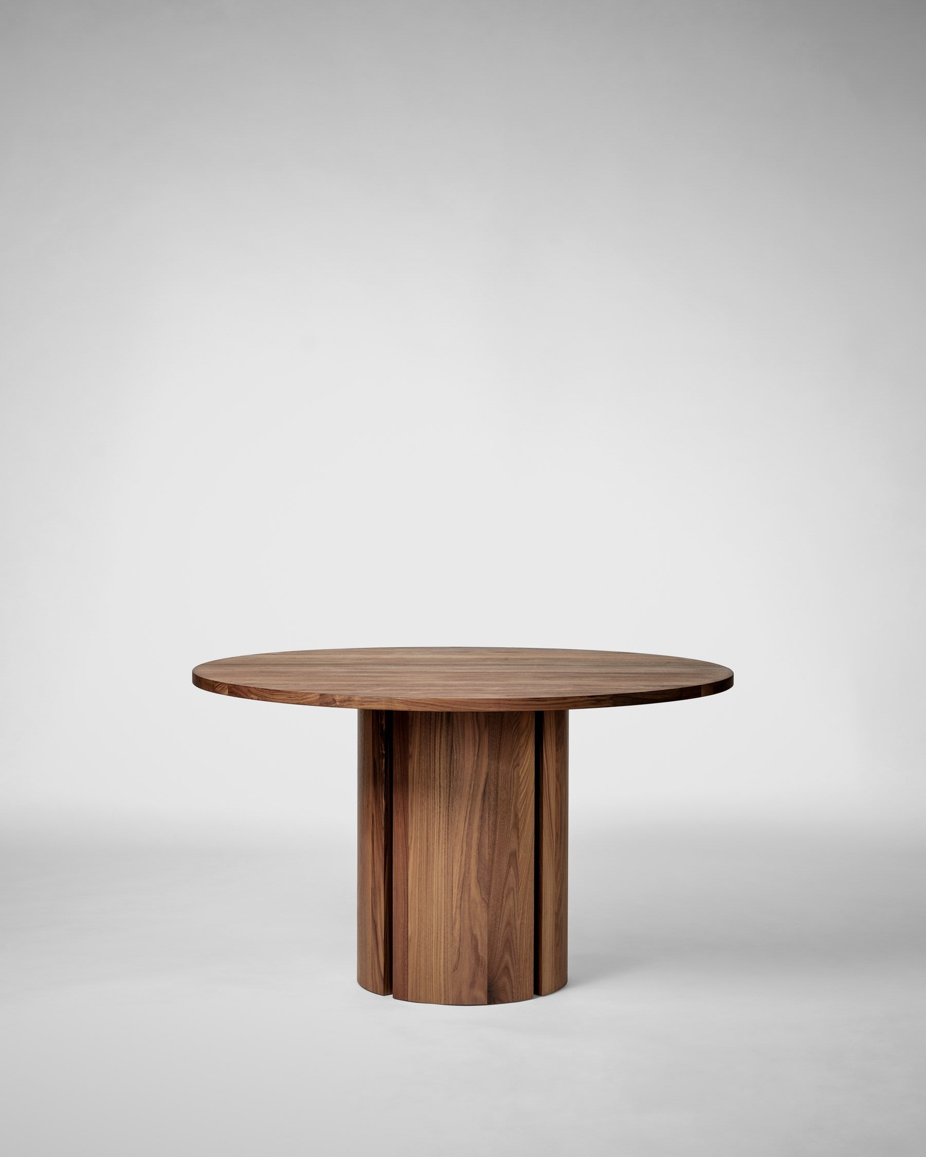 Modern walnut round dining table with cylindrical pedestal base