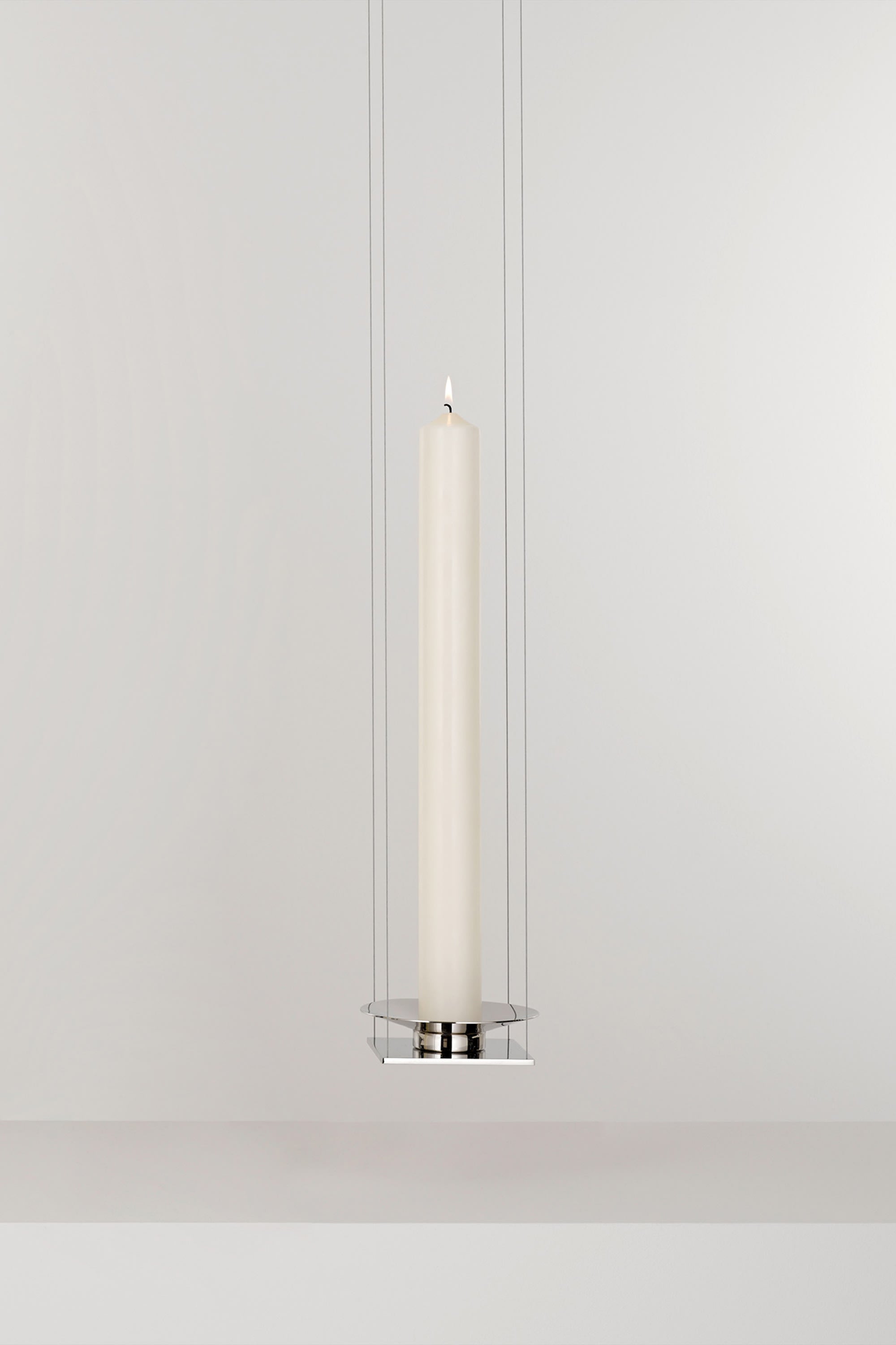 WAN PENDANT — close-up of white candle in chrome holder