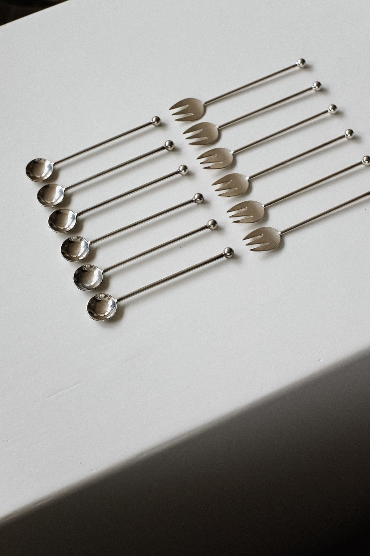 Silver-Plated Cutlery Set — arranged on white tablecloth in flat lay