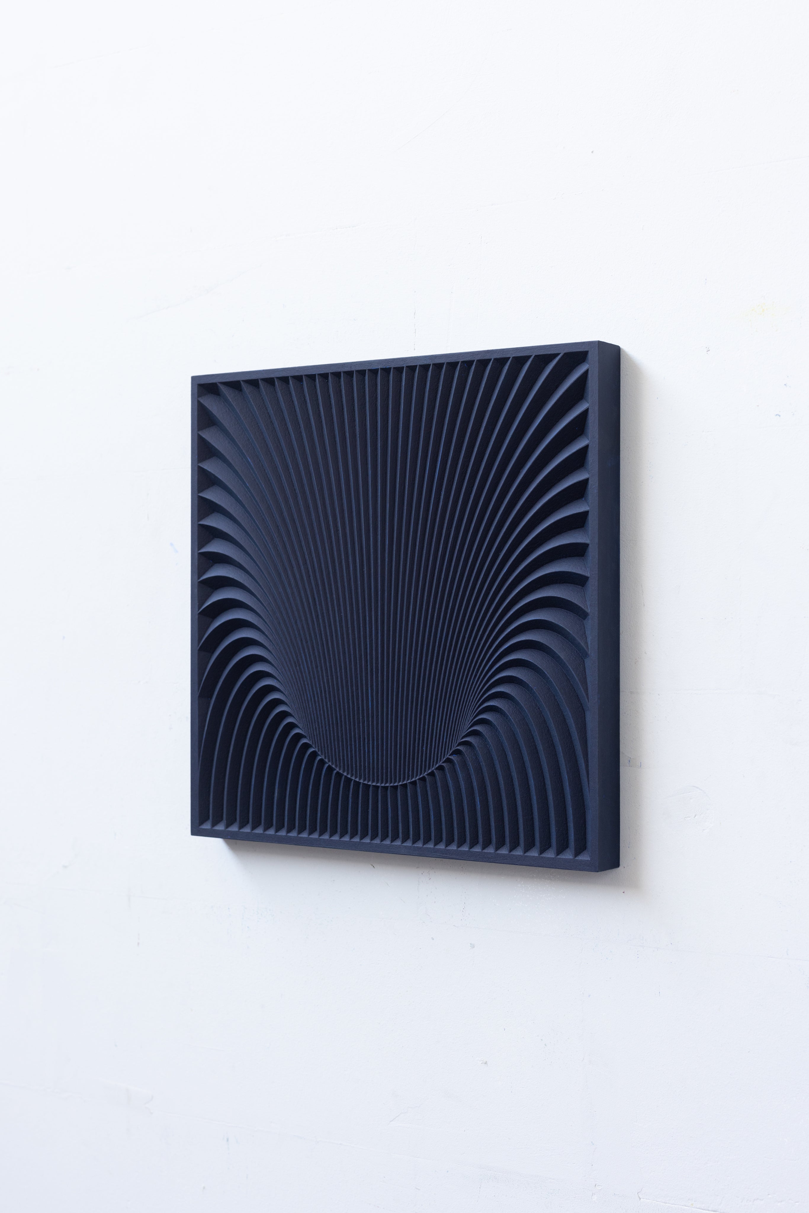 Wormhole Sculpture — navy blue wall art in minimalist setting