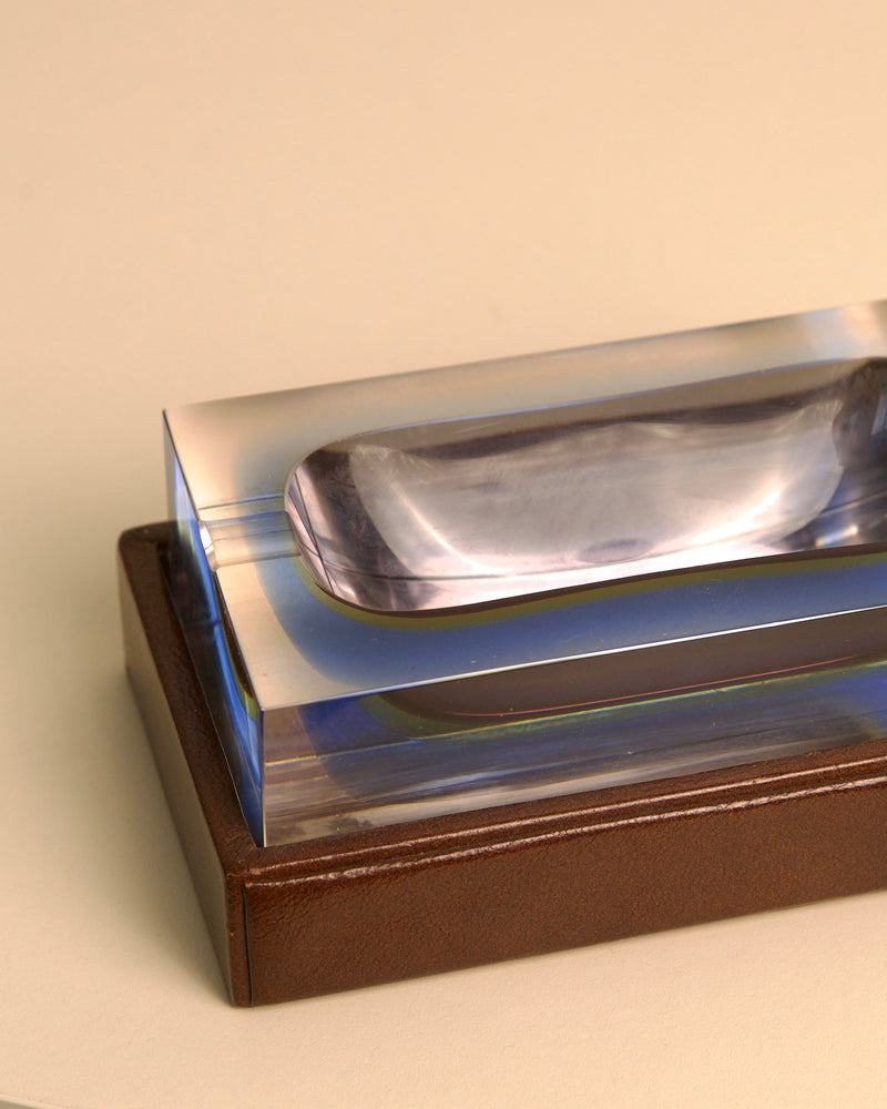 Crystal glass ashtray detail showing curved edges and leather base