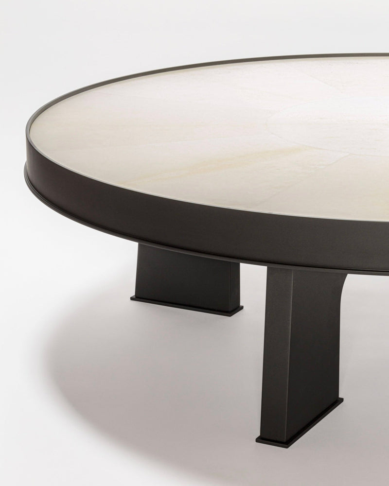 Modern round coffee table with parchment top and black base