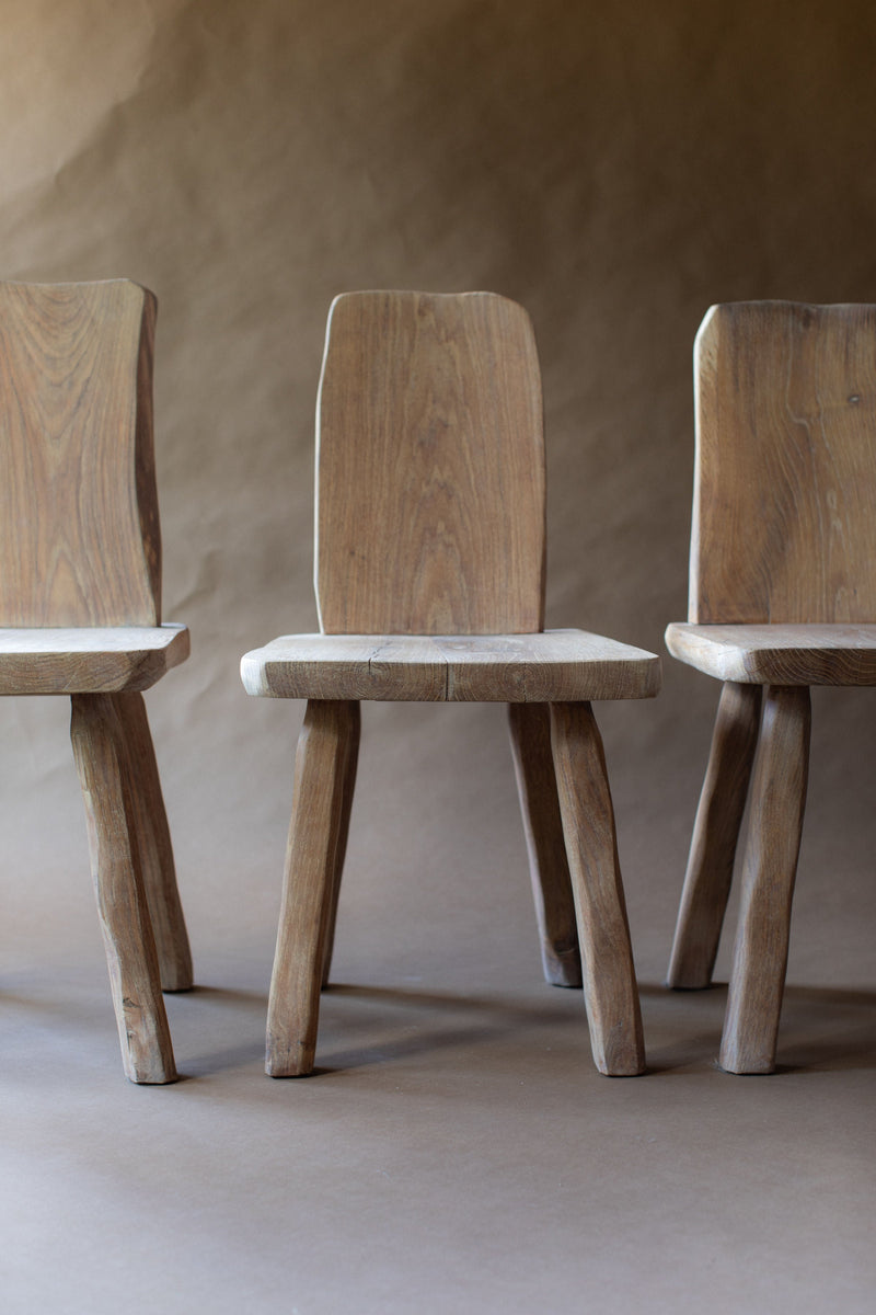 Three brutalist wooden chairs showing natural oak grain and sturdy legs