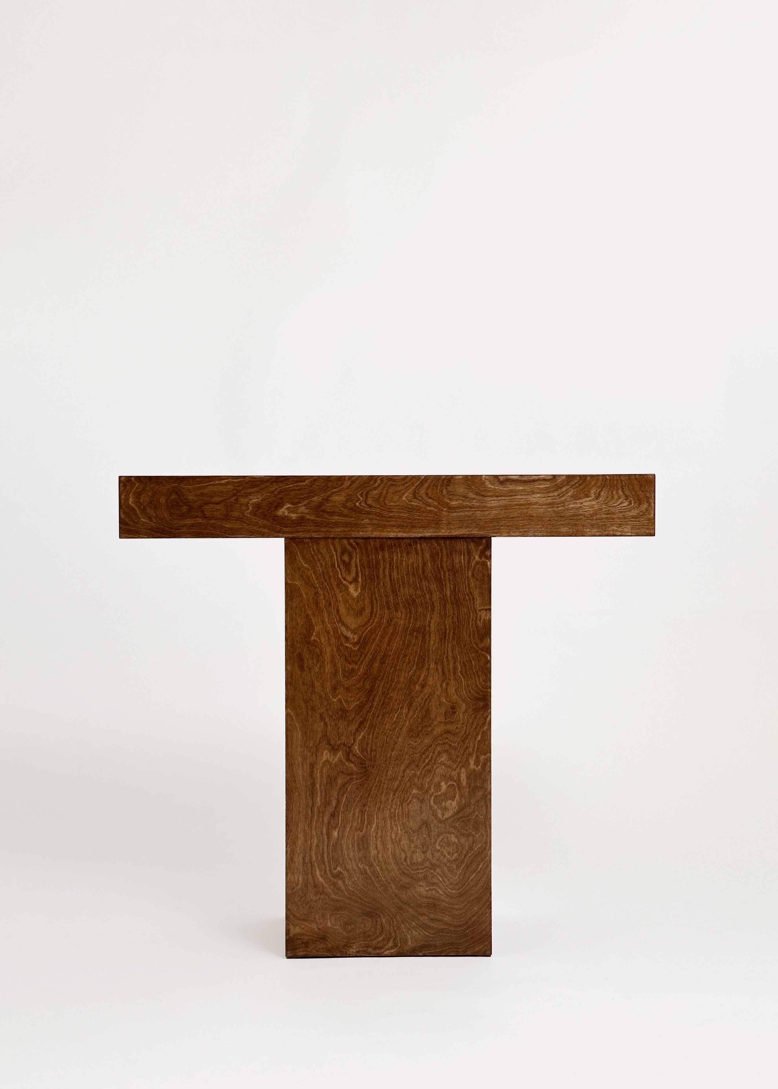 The Truss Console 02 by GOONS features a rectangular wooden top and wide base, showcasing a rich natural grain pattern inspired by Paris design studios. Photographed against a plain white background.