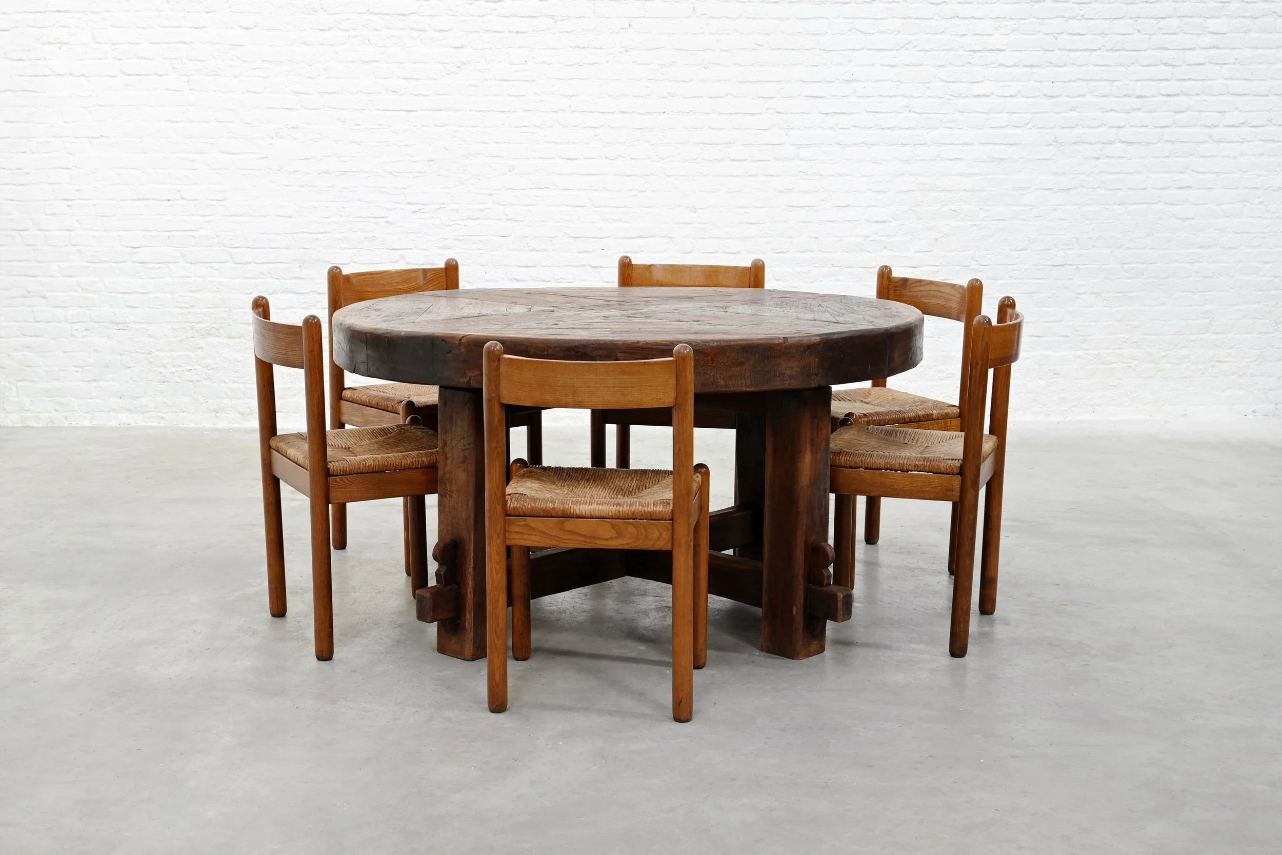 Rustic Wooden Dining Table, France 1920s — round table with six wooden chairs in minimalist setting
