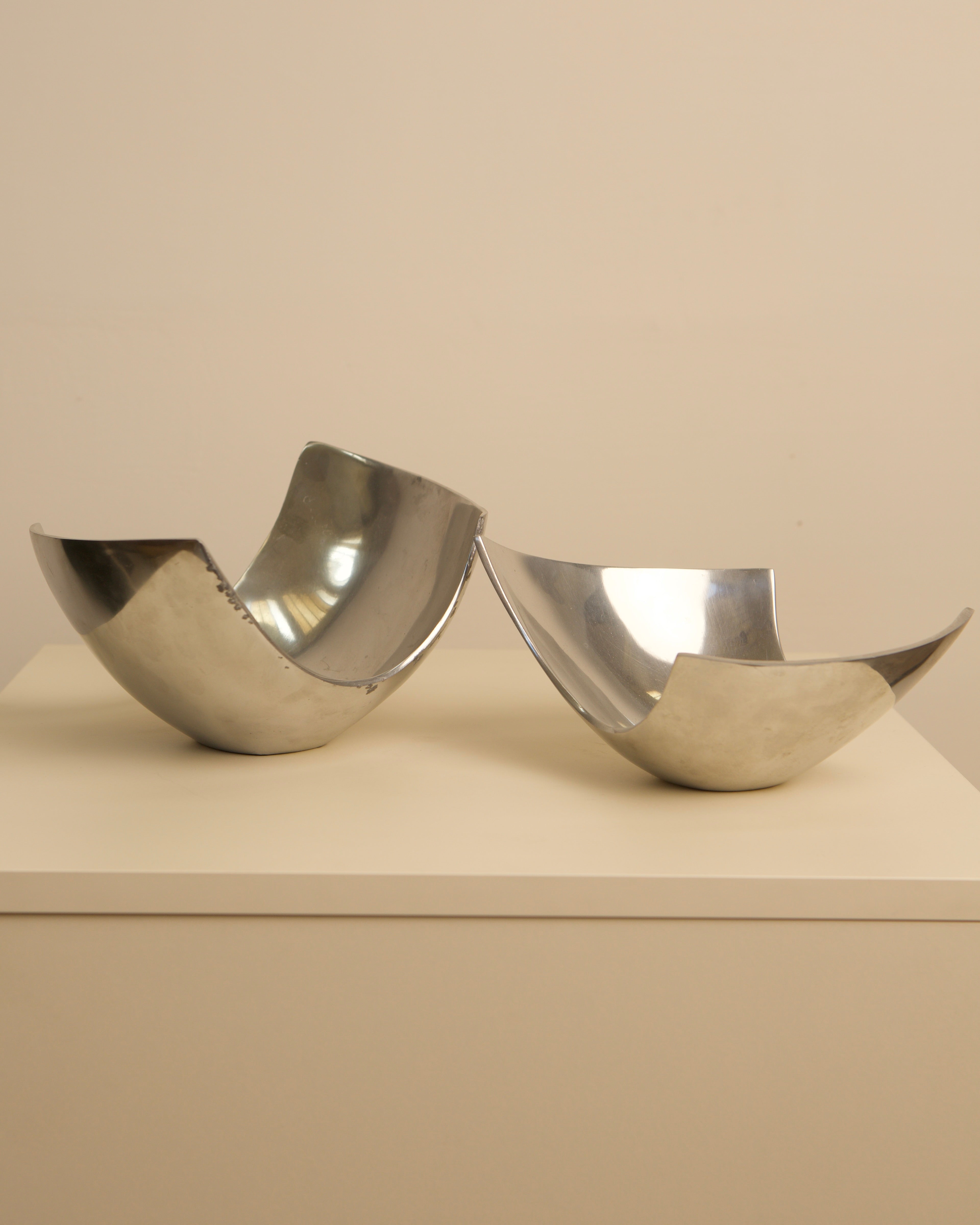 Polished steel Italian fruit baskets showing curved sculptural form
