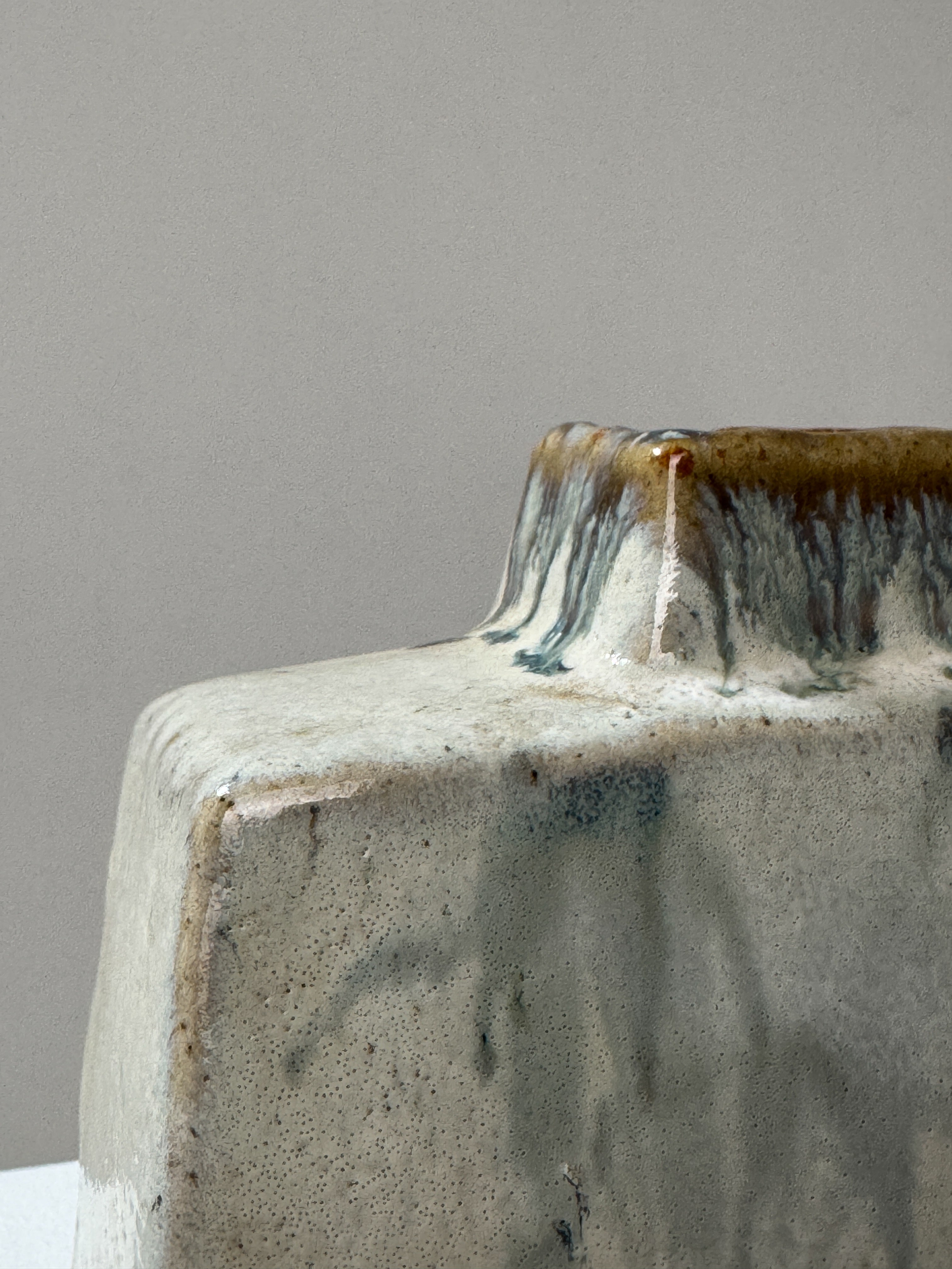 Handcrafted ceramic vase with dripped glaze detail and speckled texture