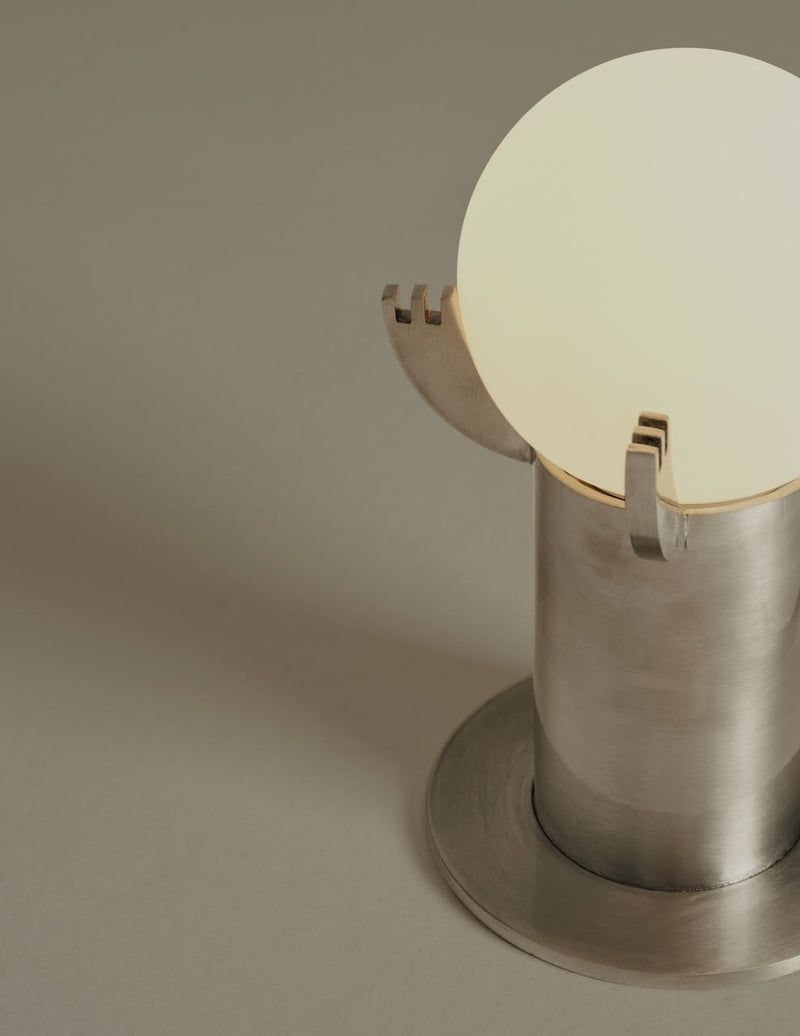 Mago table lamp detail view showing brushed metal base and glowing orb